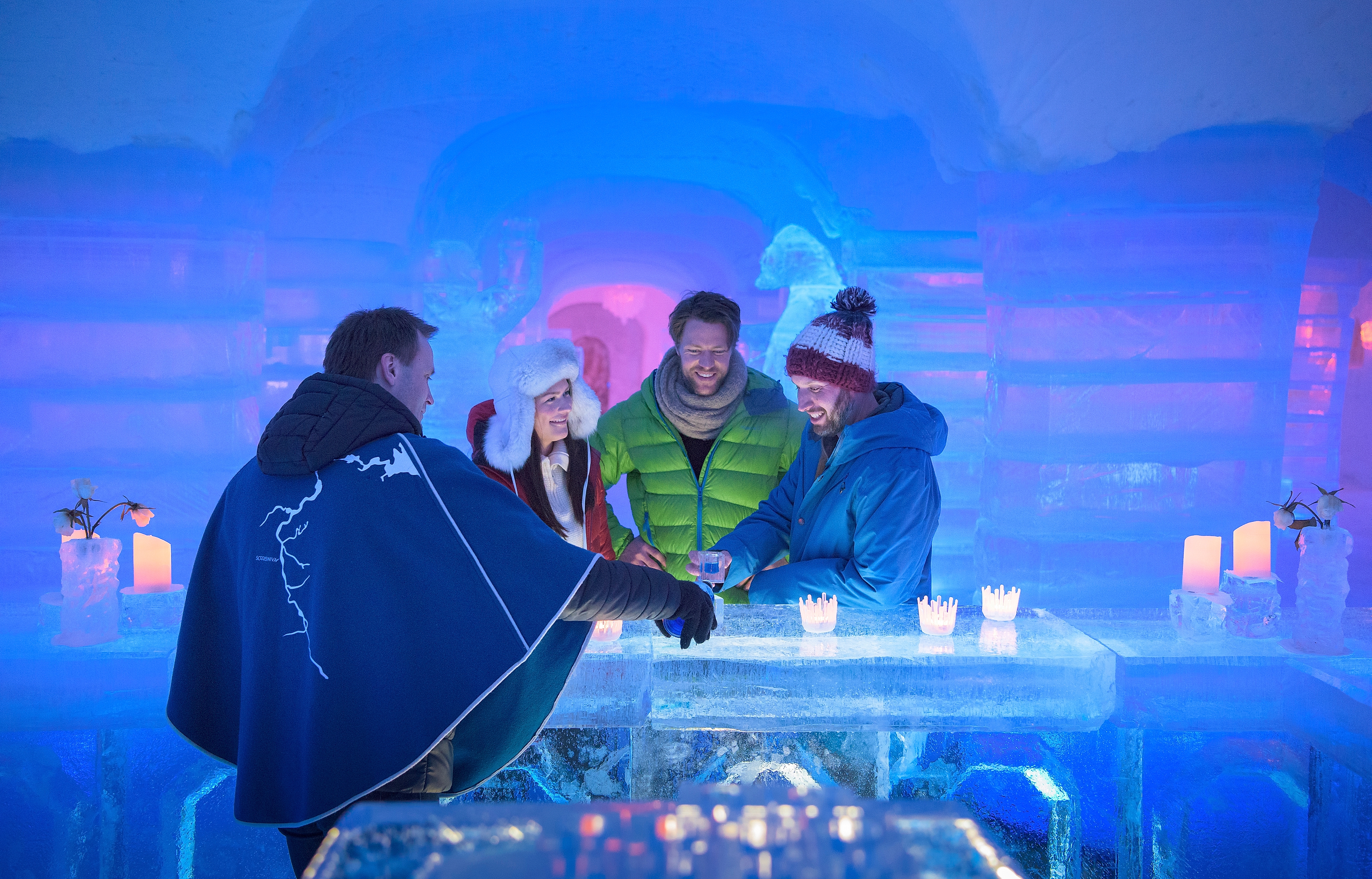Four persons having a drink at the bar of the Sorrisniva Igloo Hotel in Alta, Northern Norway