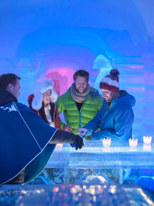 Four persons having a drink at the bar of the Sorrisniva Igloo Hotel in Alta, Northern Norway