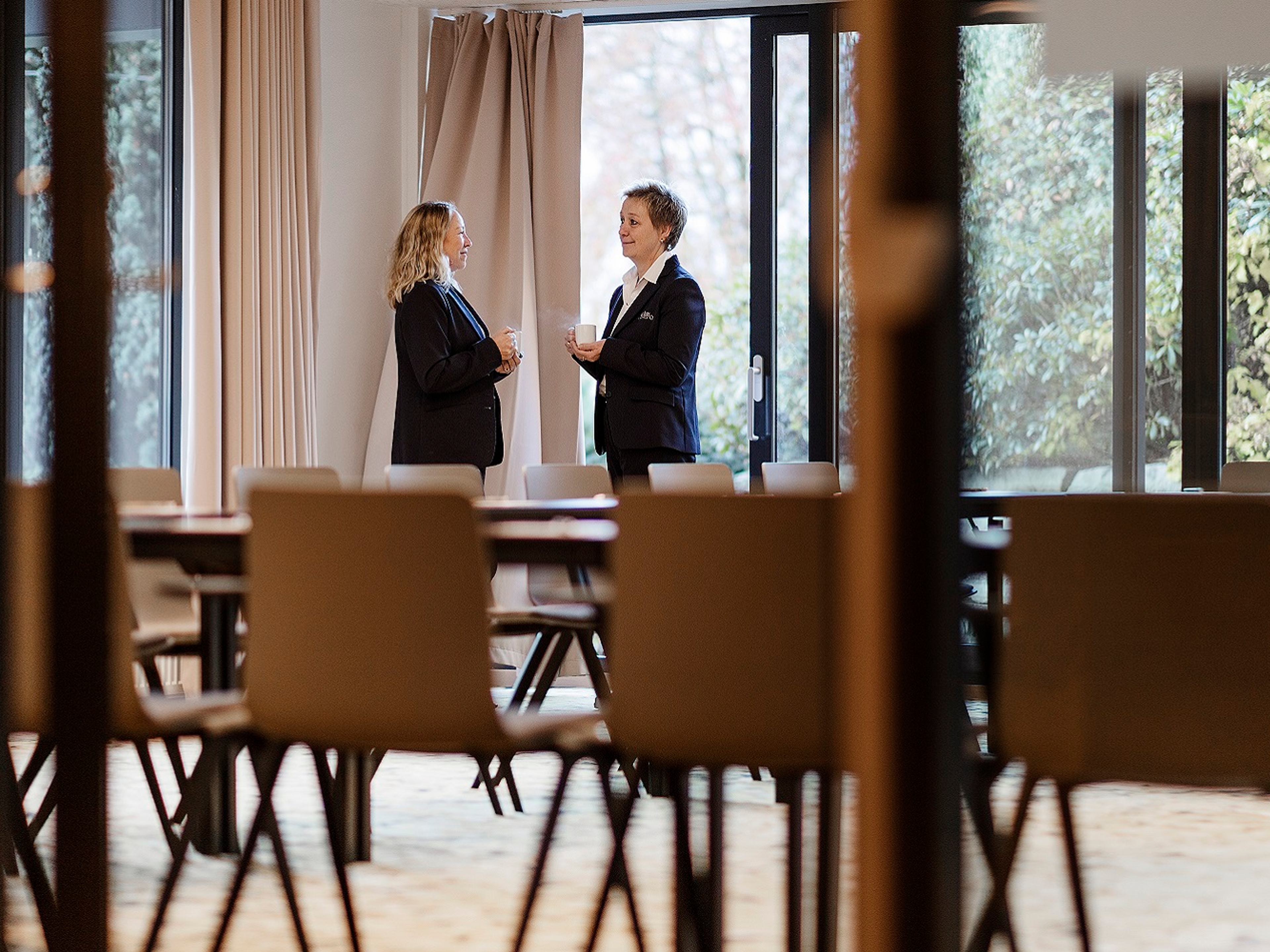 Staff at Hotel Alexandra in Loen, Norway, engaged in conversation in an empty dining room