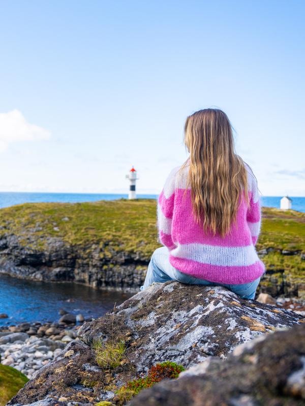 A woman looking at the view of Børhella lighthouse at Andøya, Northern Norway