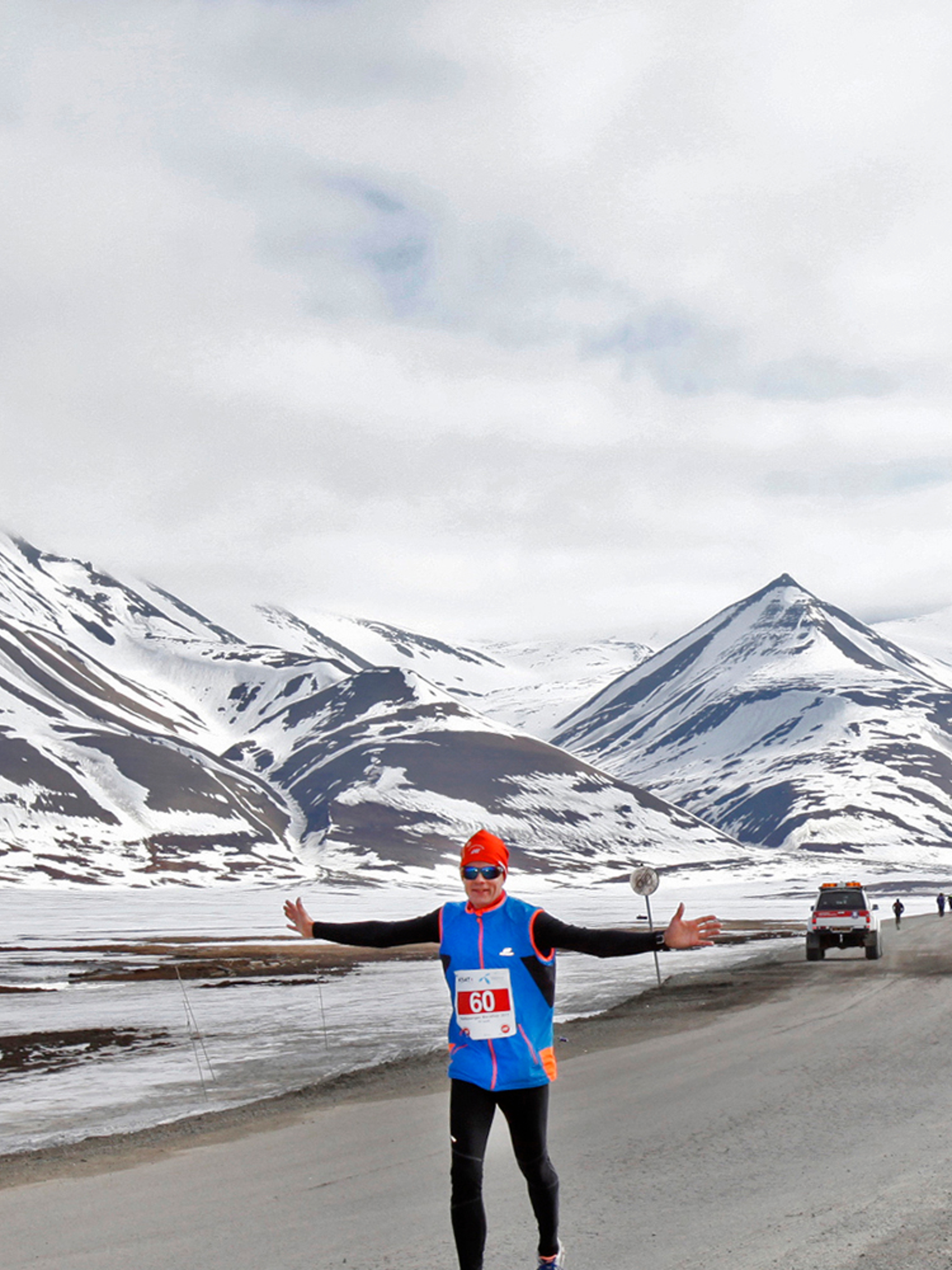 A marathon runner passing a polar bear warning sign in Spitsbergen in Svalbard