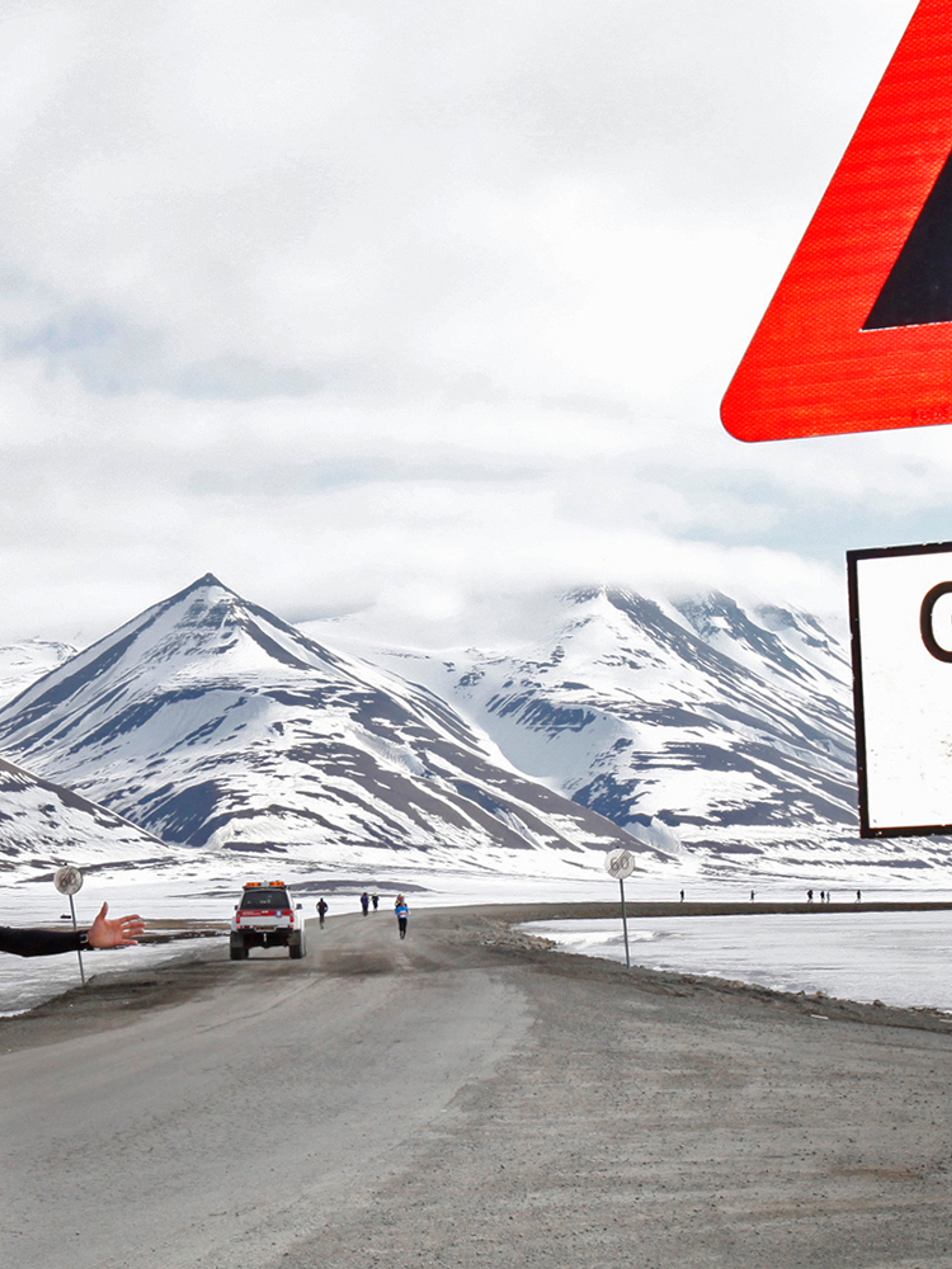 En maratonløper passerer et isbjørnskilt på Spitsbergen, Svalbard