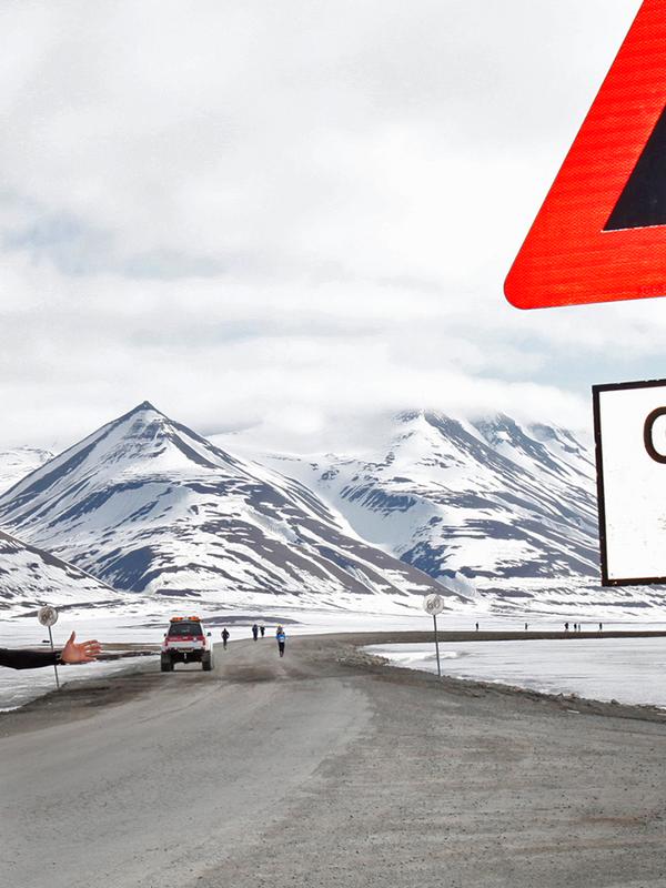 En maratonløper passerer et isbjørnskilt på Spitsbergen, Svalbard