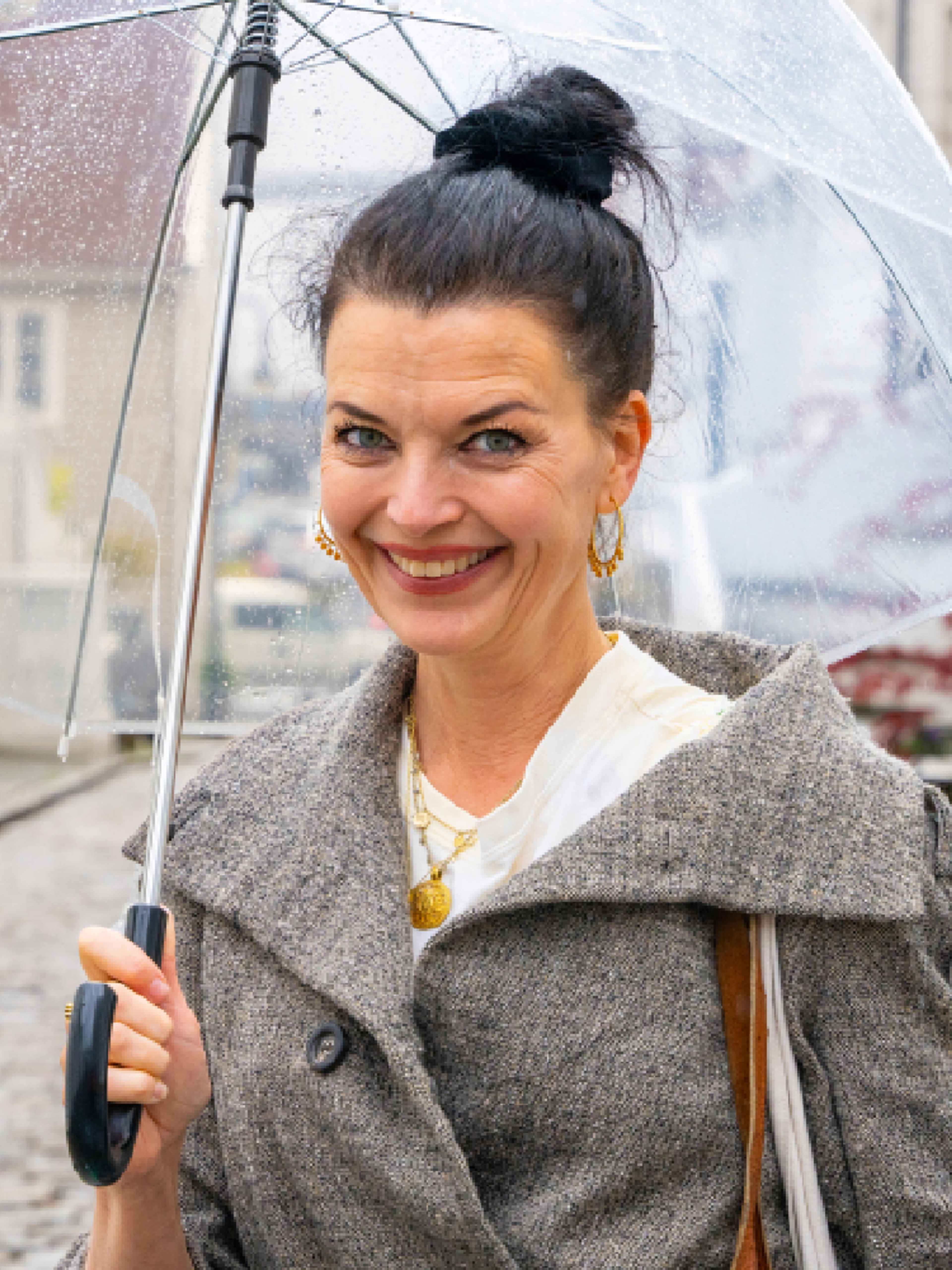 A woman stands under an umbrella in the Pedersgata street in Stavanger, Fjord Norway.