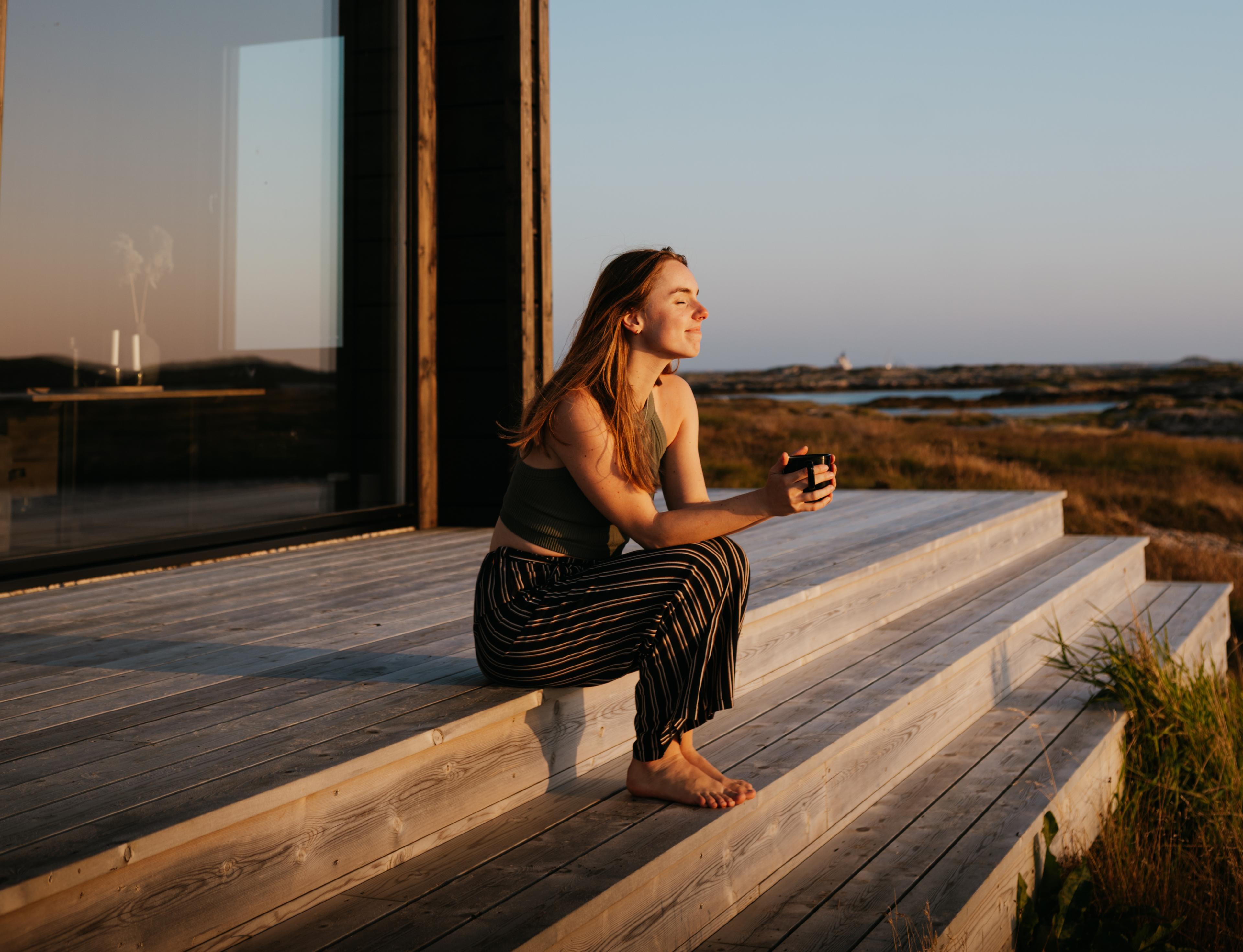 Kvinne slapper av på Sula Havglamping