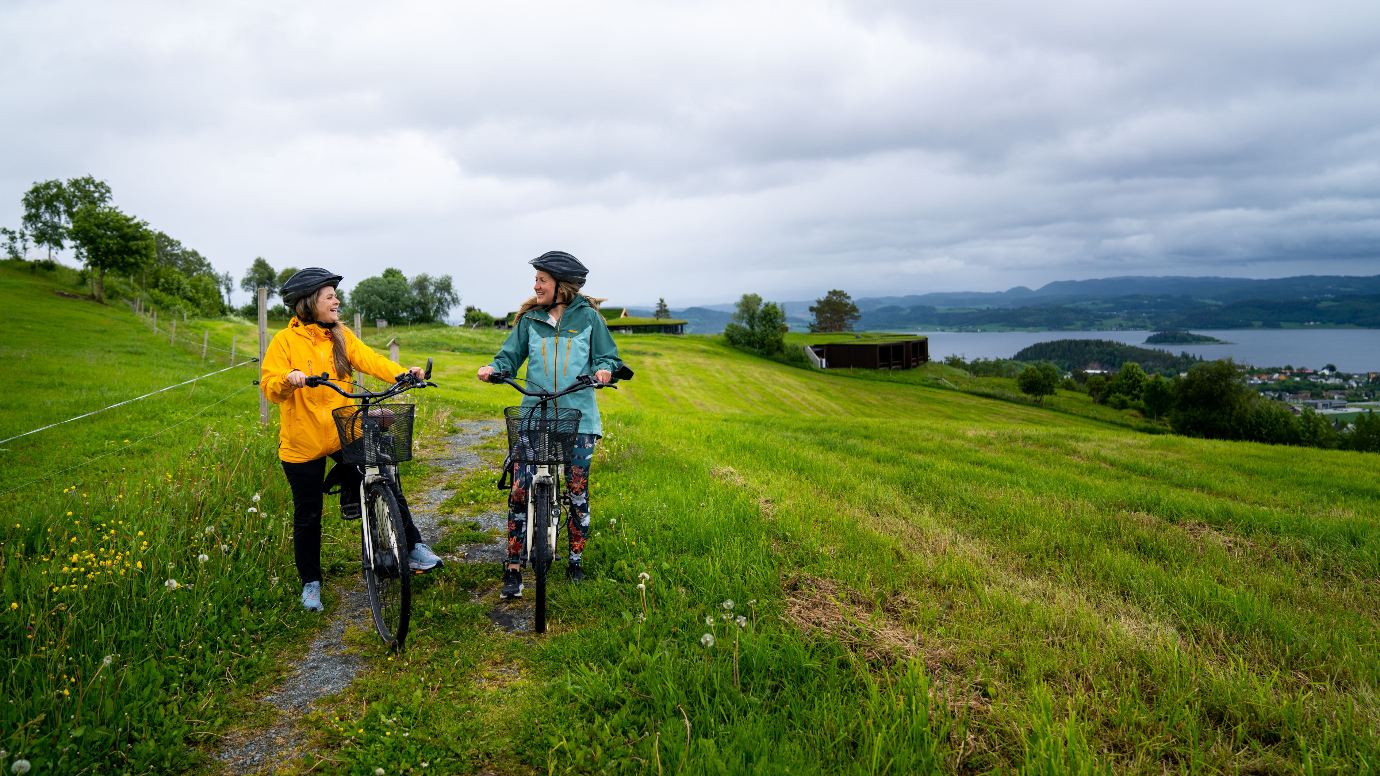 Two woman cycling between Husfrua Farm Hotel and Øyna cultural landscape hotel