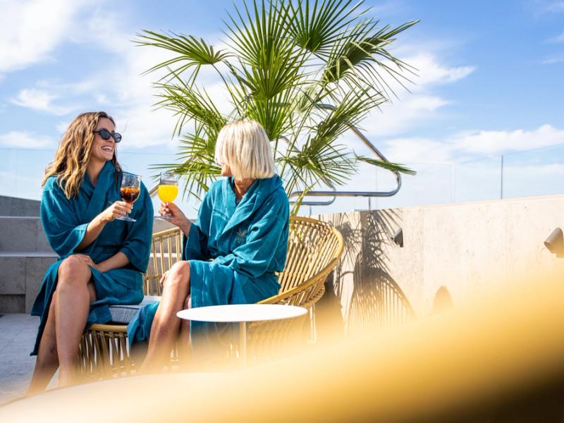 Two women cheering on the roof top of Hotel Riviera in Moss