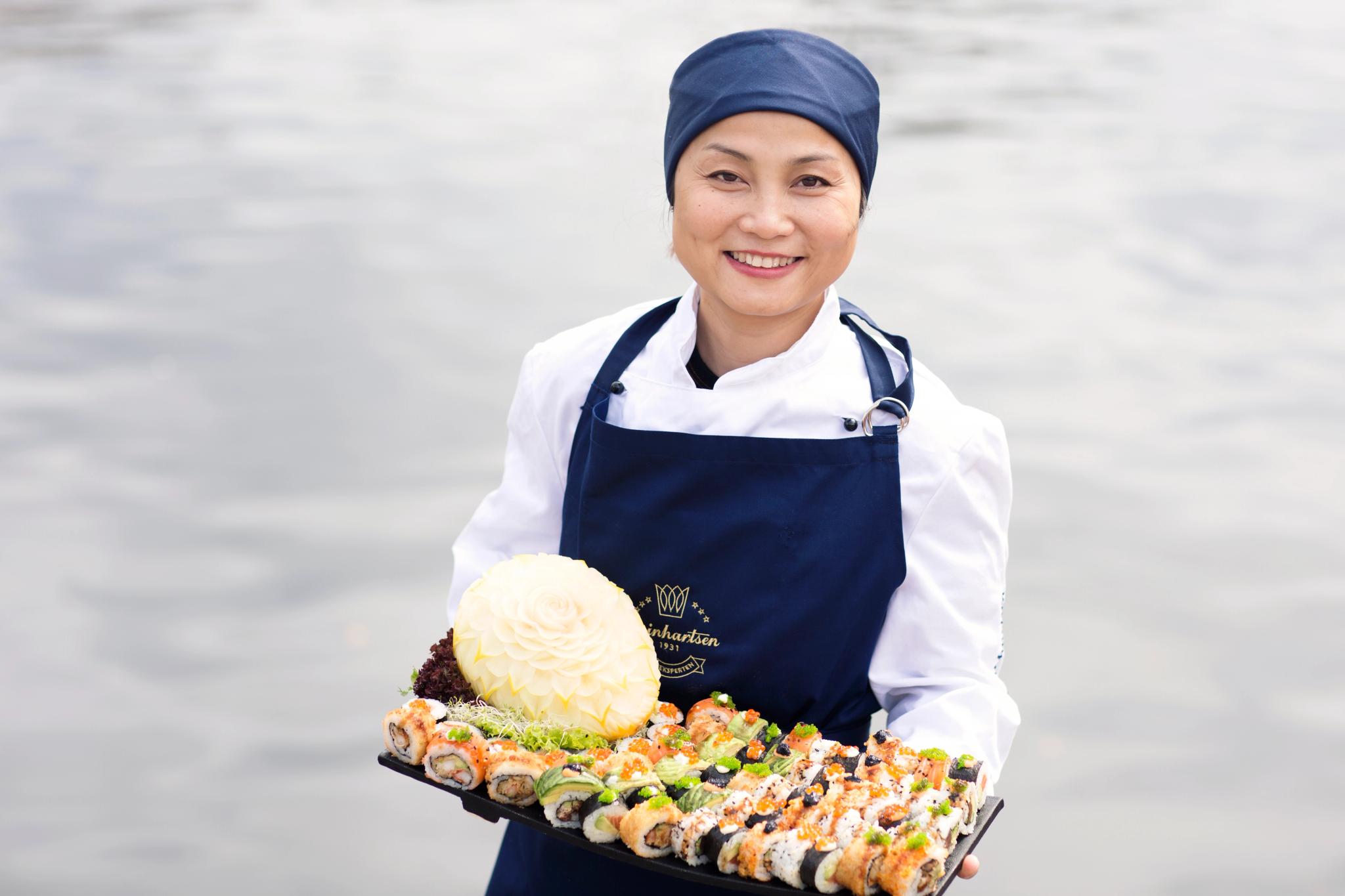 Chef holding a large platter of sushi, from Reinhartsen