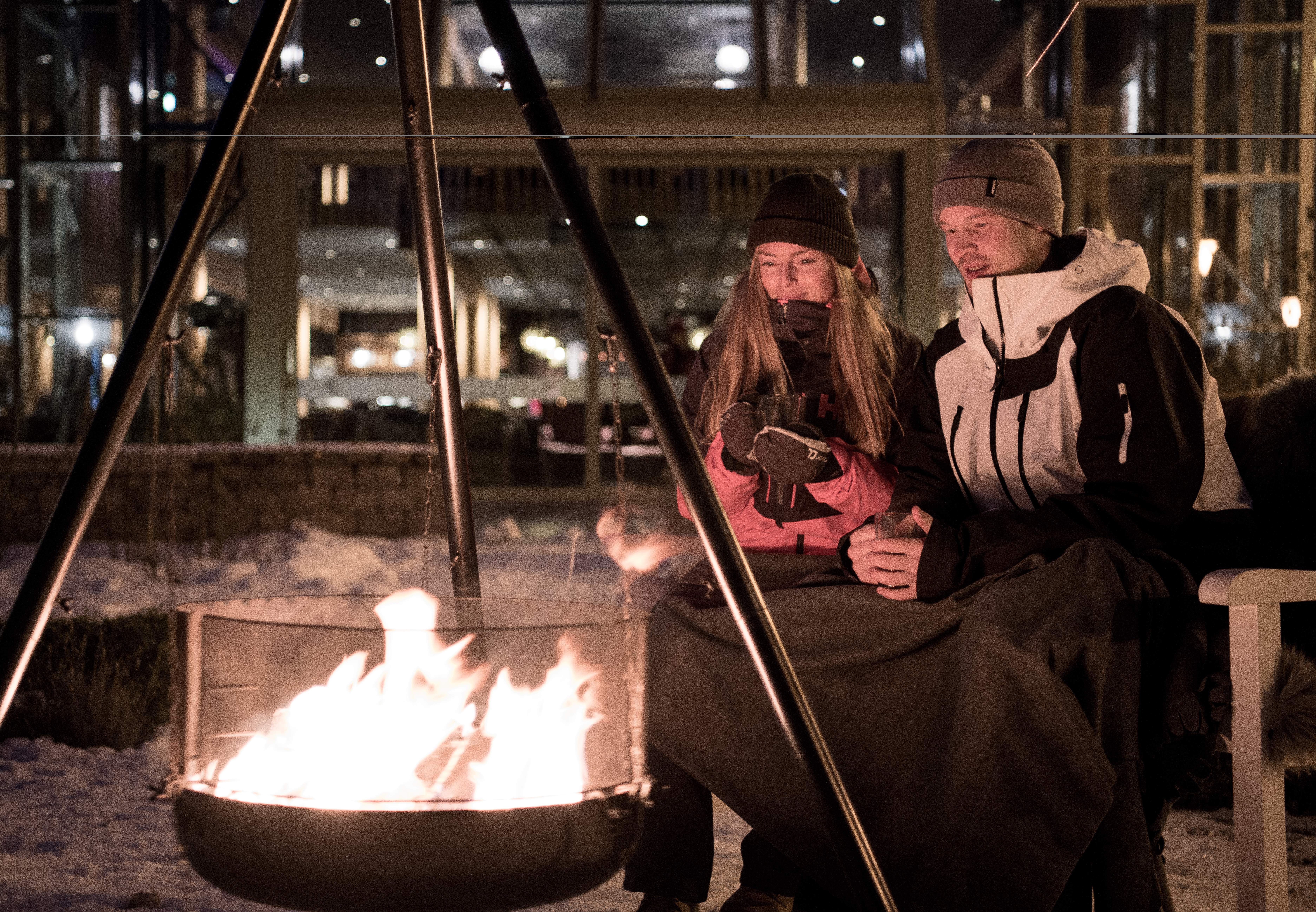 People sitting around the bonfire outside Fretheim Hotel in Flåm