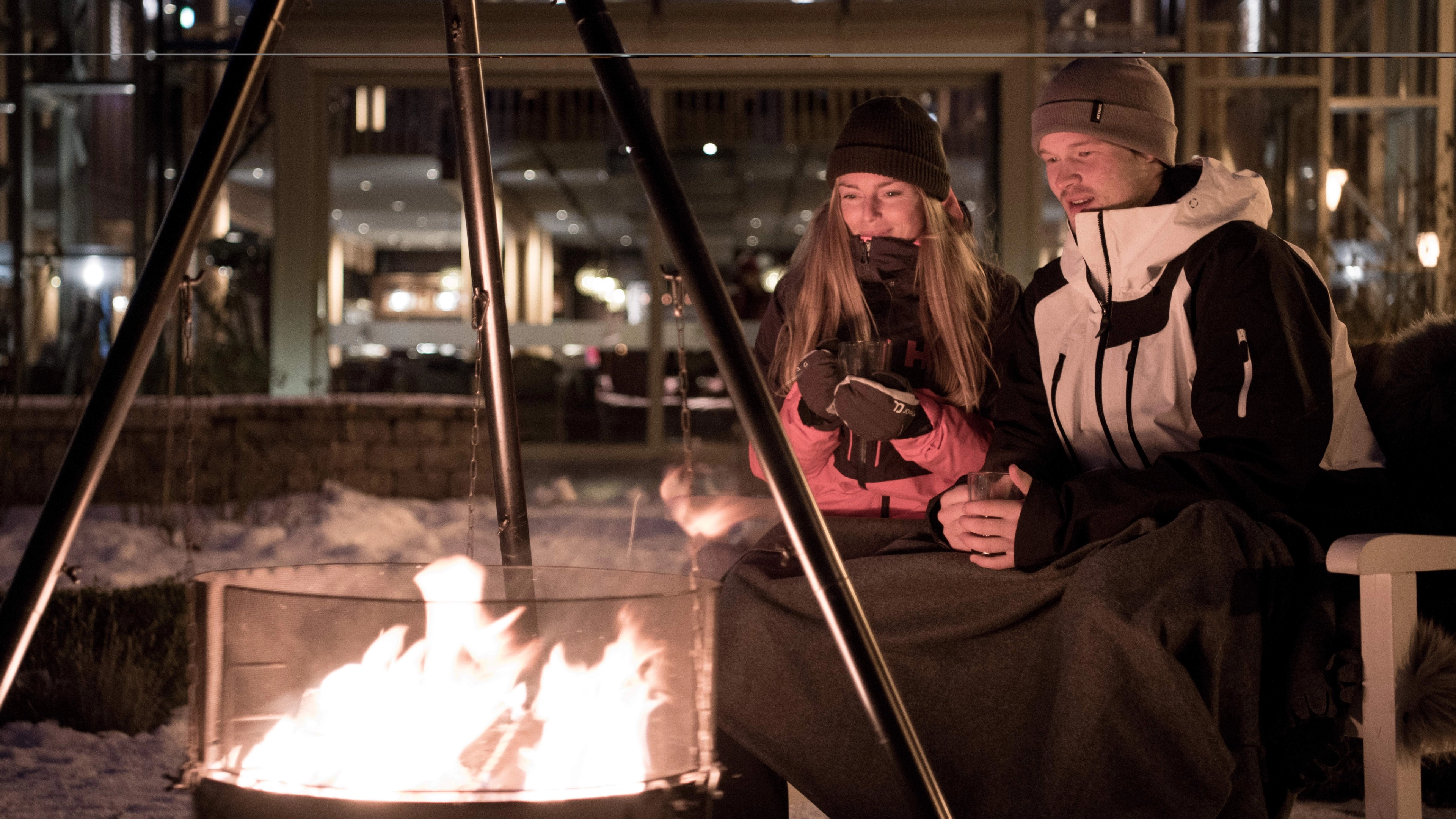 People sitting around the bonfire outside Fretheim Hotel in Flåm