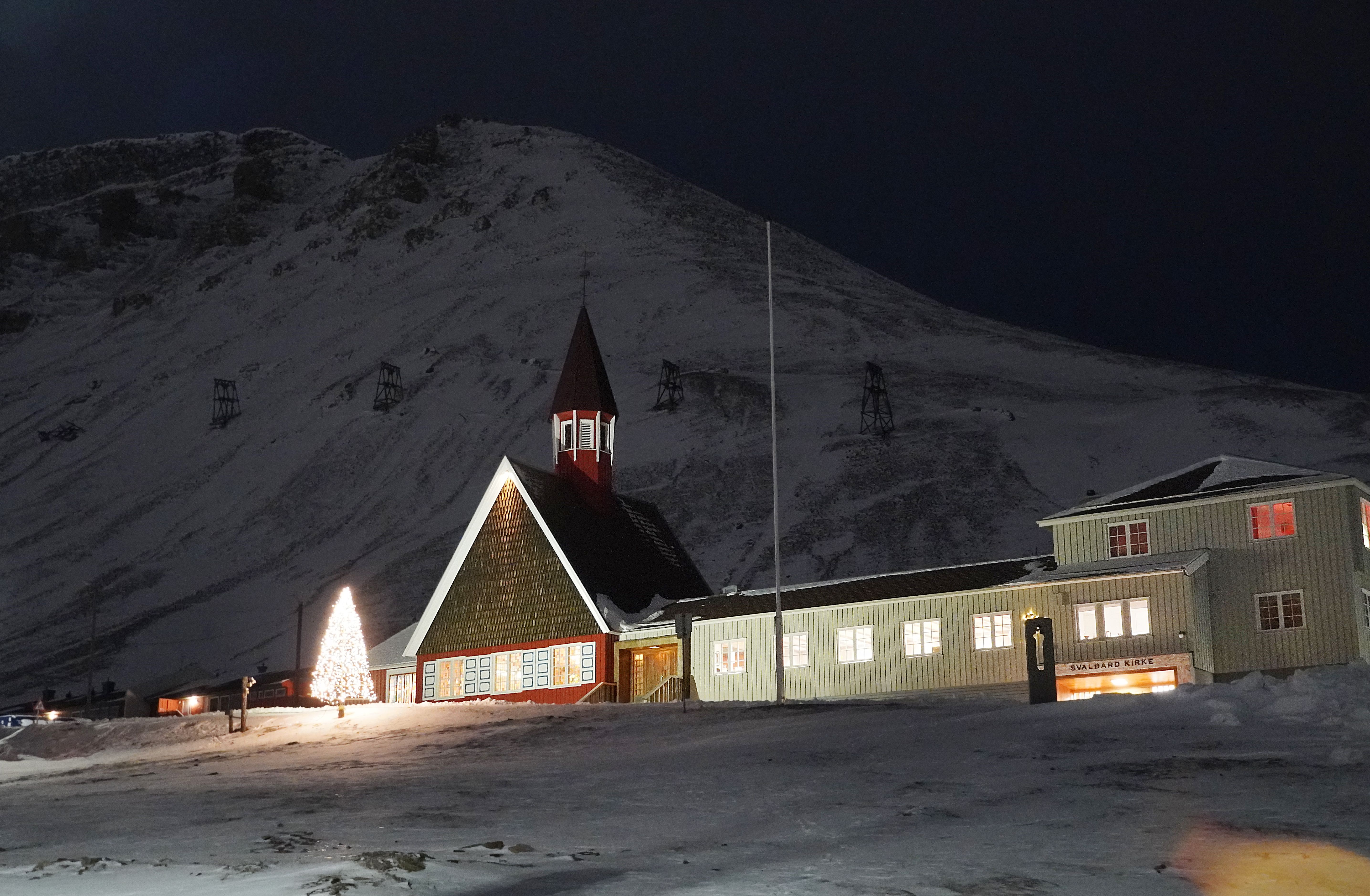 A church in front of a big, white mountain