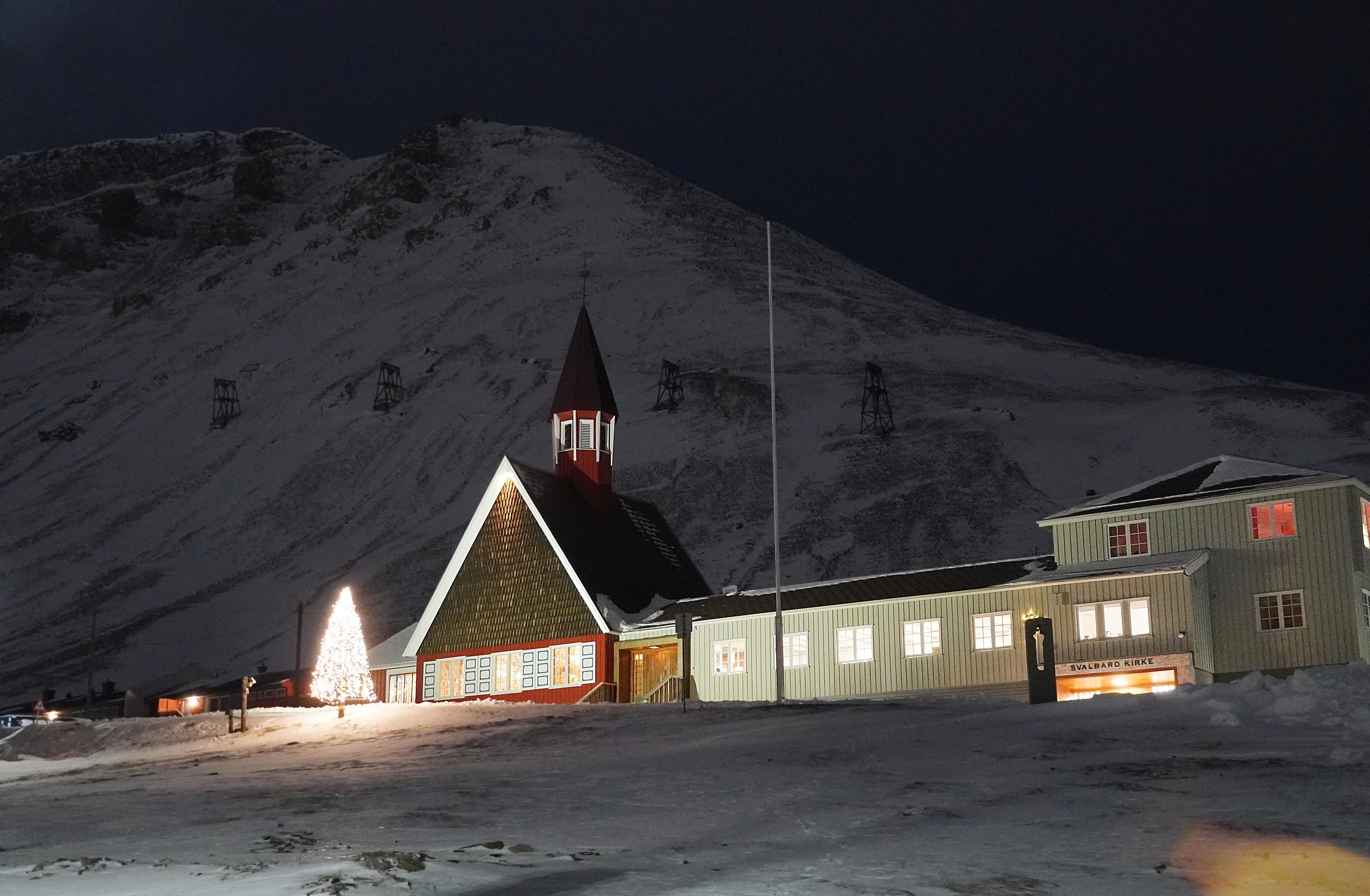 A church in front of a big, white mountain