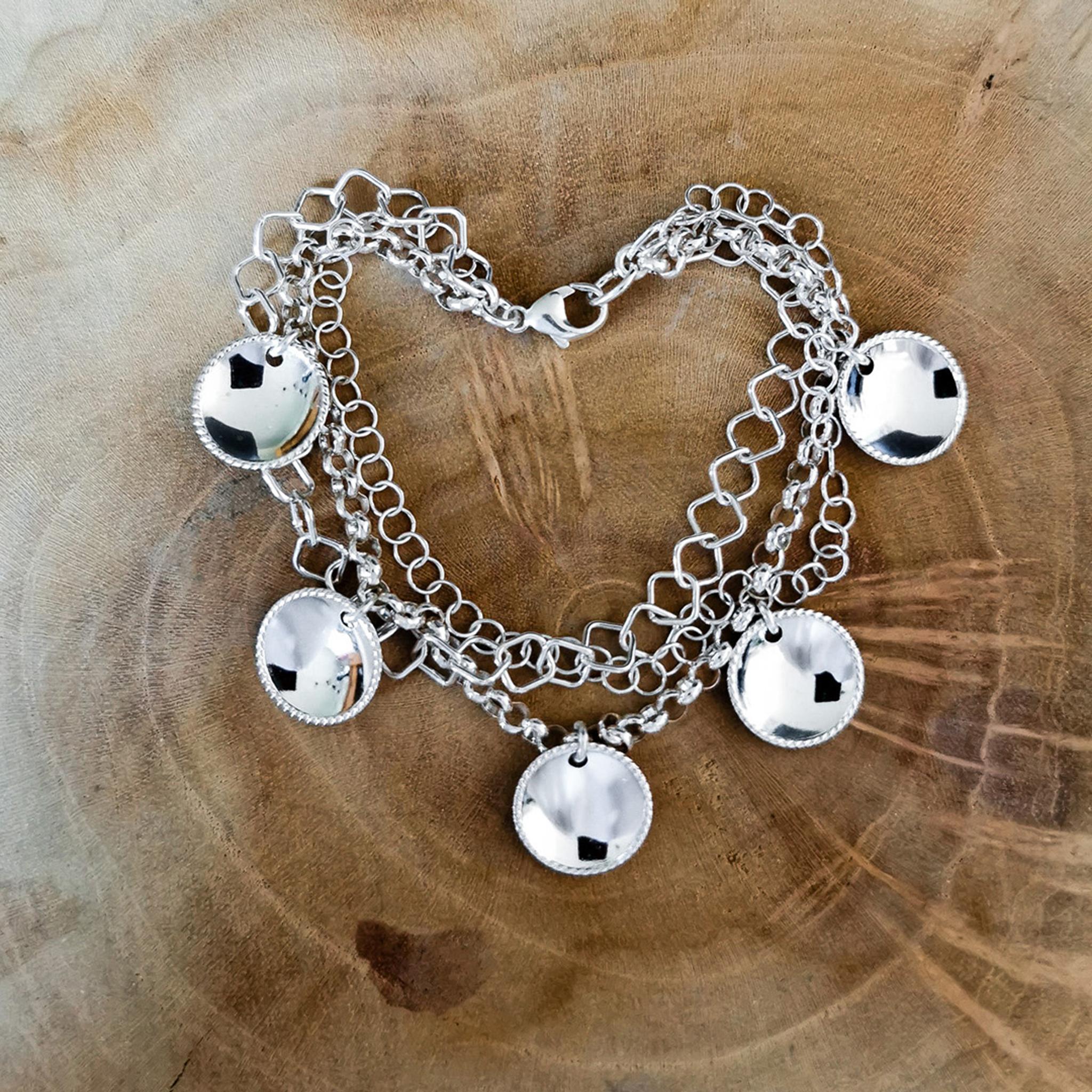 Silver bracelet resting on a slab of wood