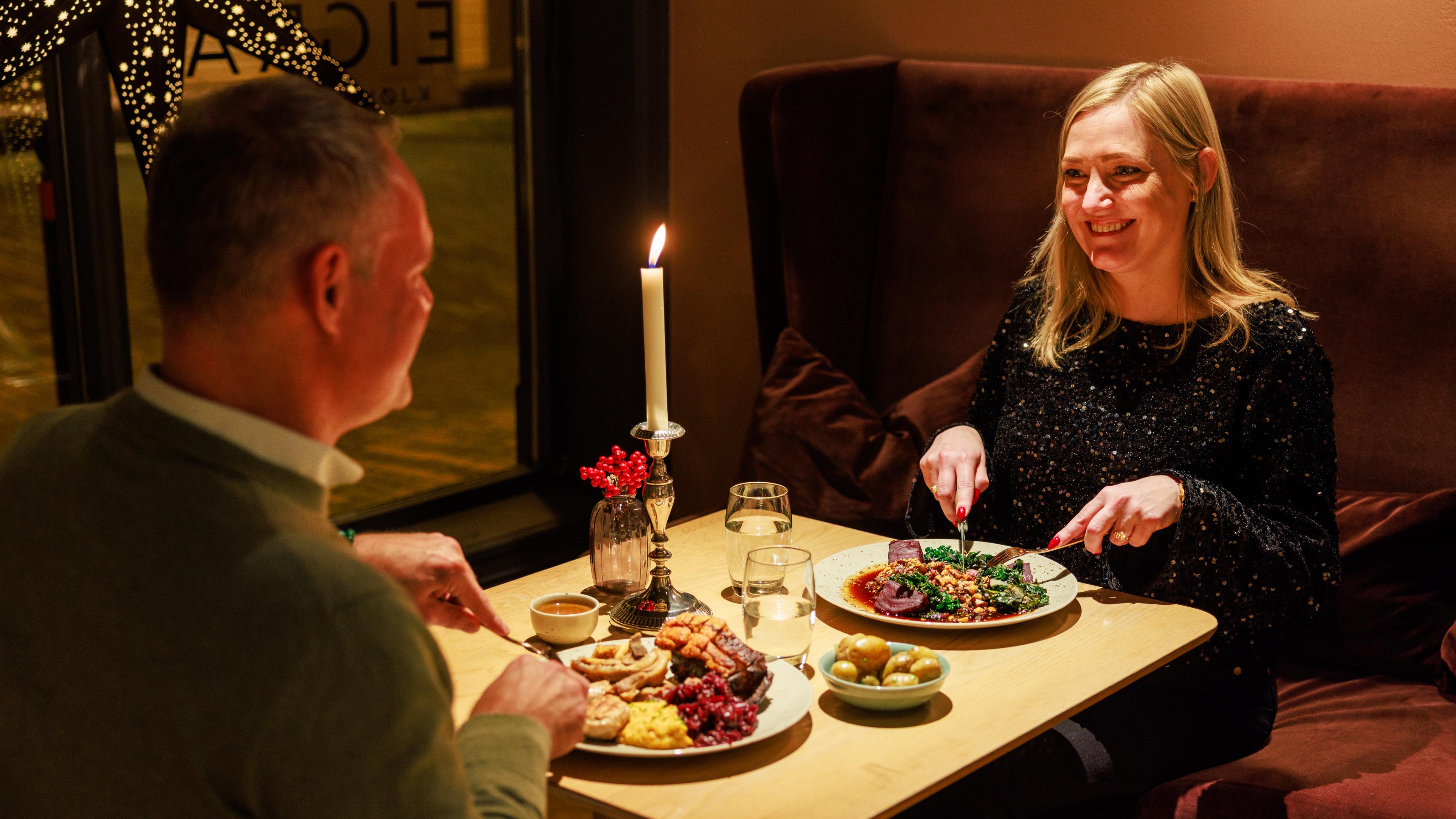 Two friends enjoying a cozy and festive dinner at Eigra restaurant, located in Grand Hotell in Egersund,