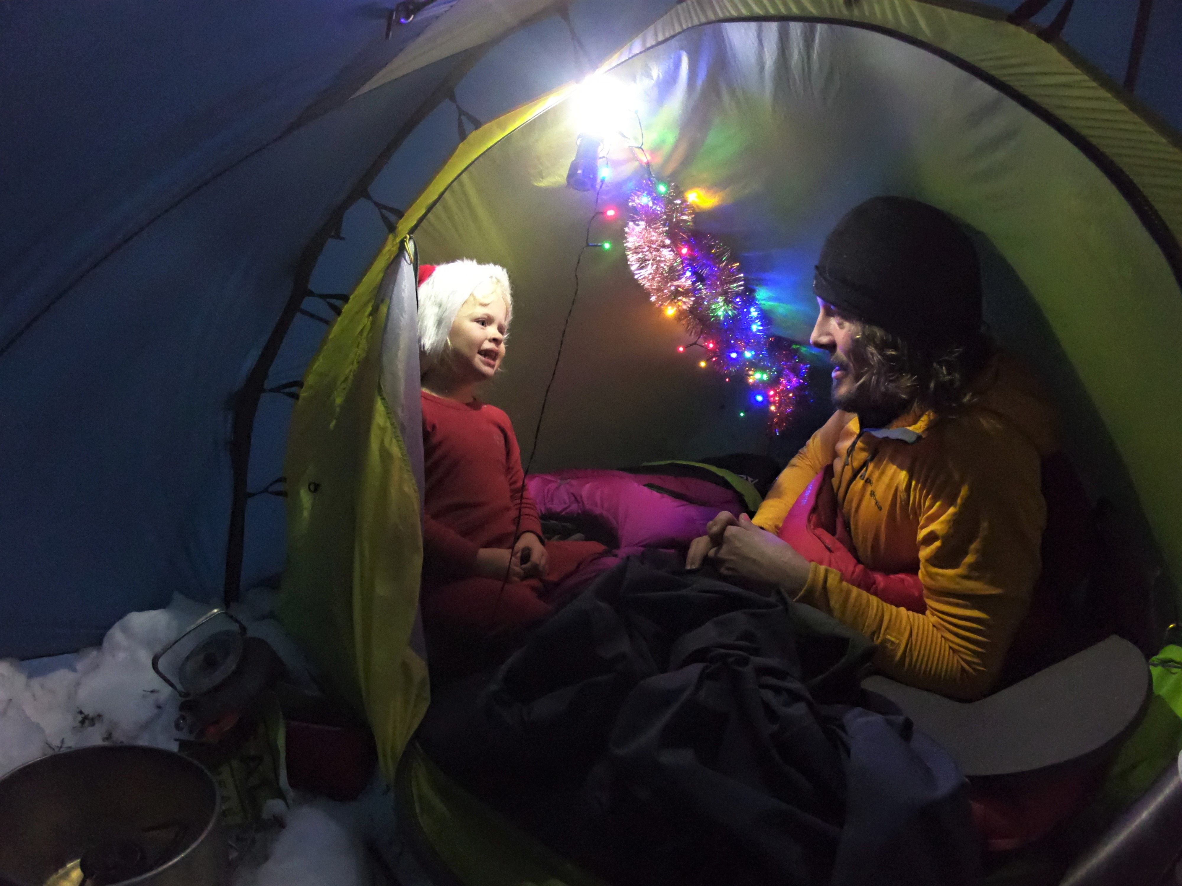 Mina and Alexander relaxing inside a Christmas decorated tent in Rondane national park
