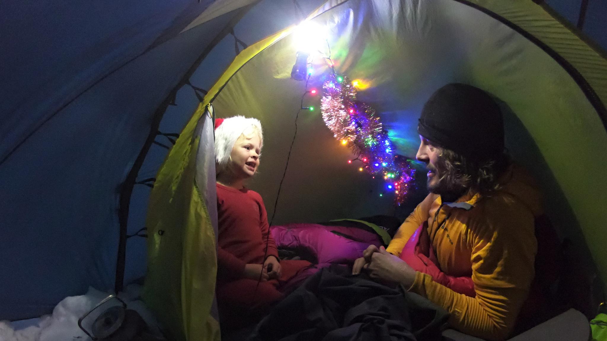 Mina and Alexander relaxing inside a Christmas decorated tent in Rondane national park