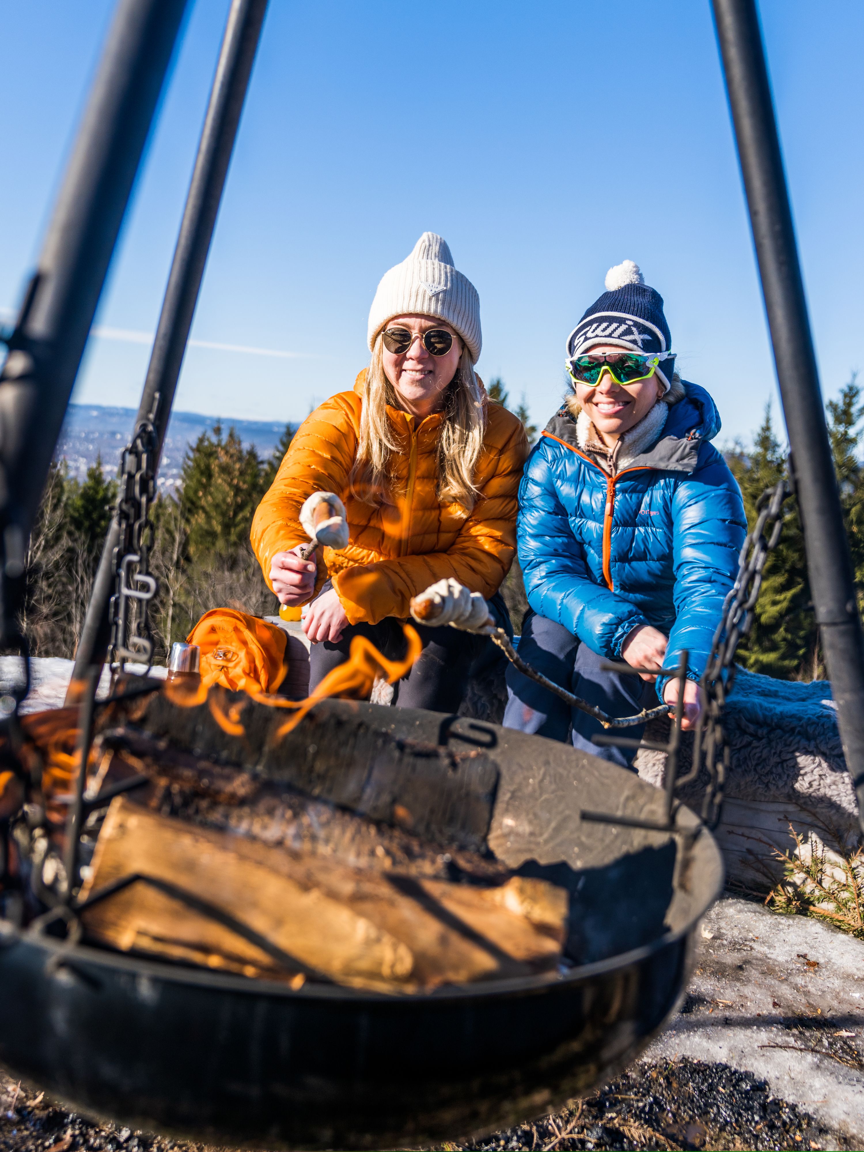 People making pinnebrød at the campfire in the woods, Grefsenkollen, Norway