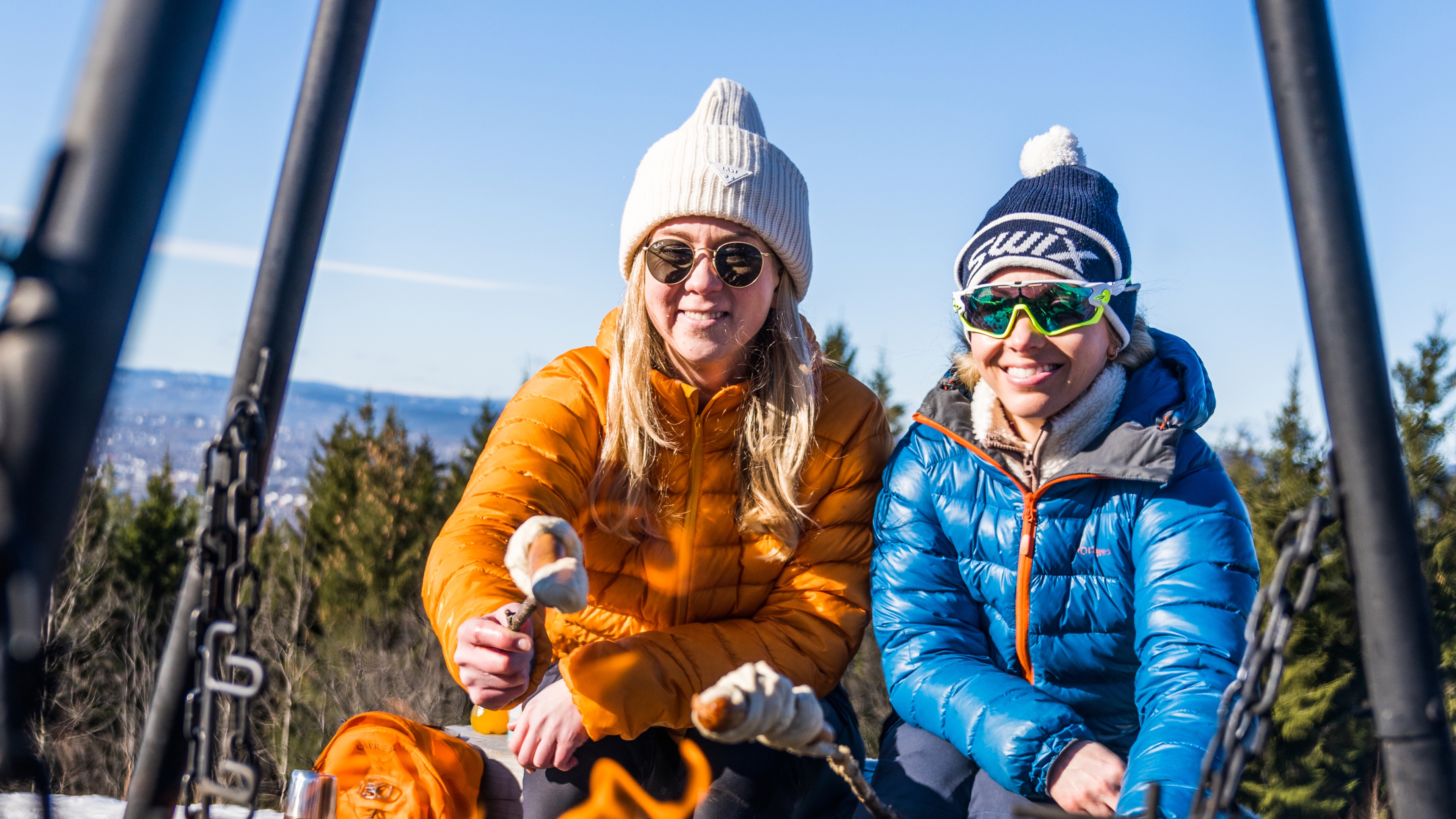 People making pinnebrød at the campfire in the woods, Grefsenkollen, Norway