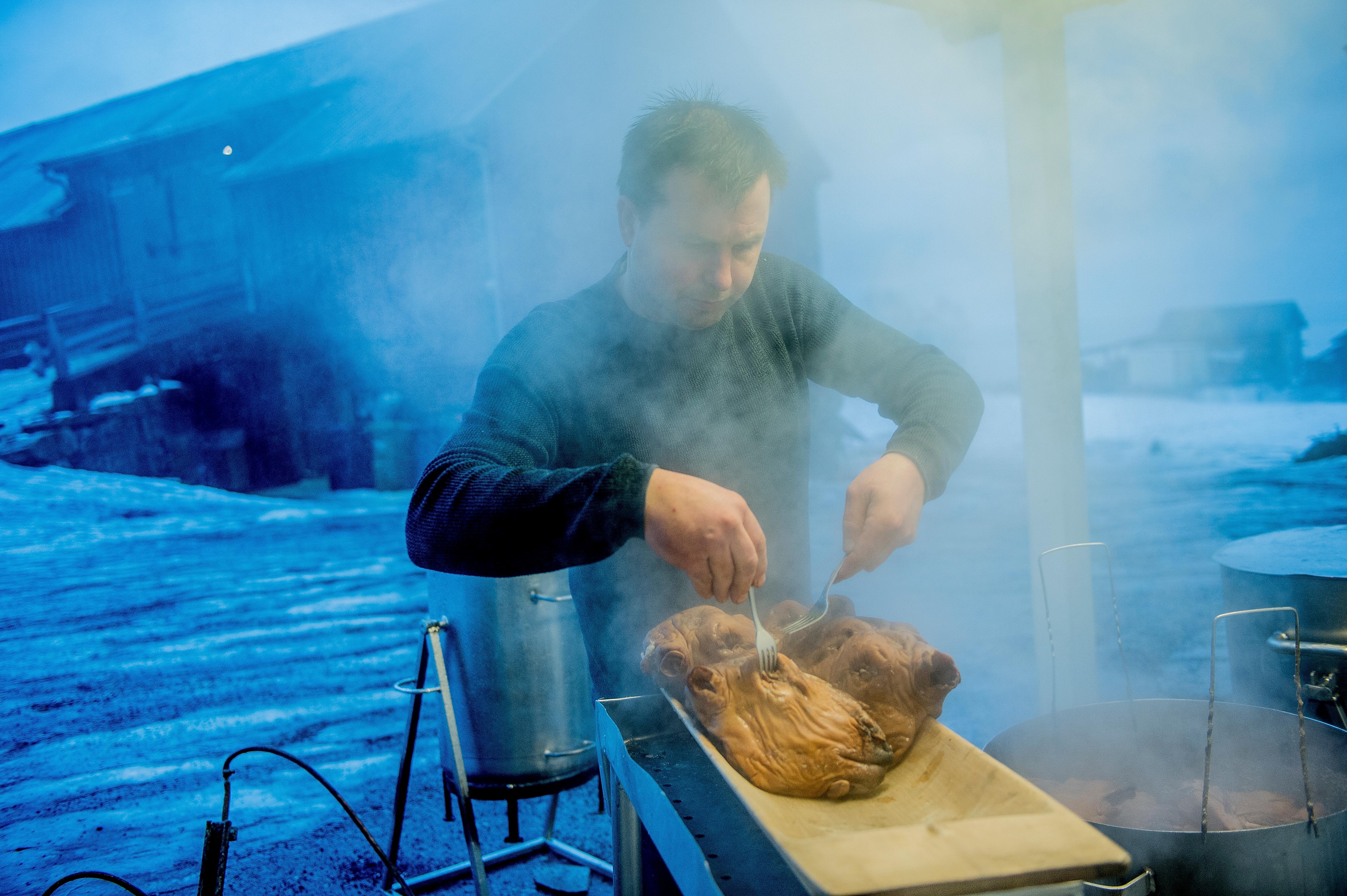 A person preparing a smalahove sheep’s head at Smalahovetunet in Voss, Fjord Norway