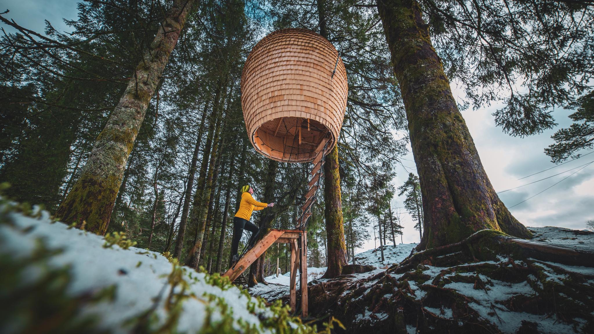 Woman climbing a ladder to the Cone at Mount Fløyen - Konglen