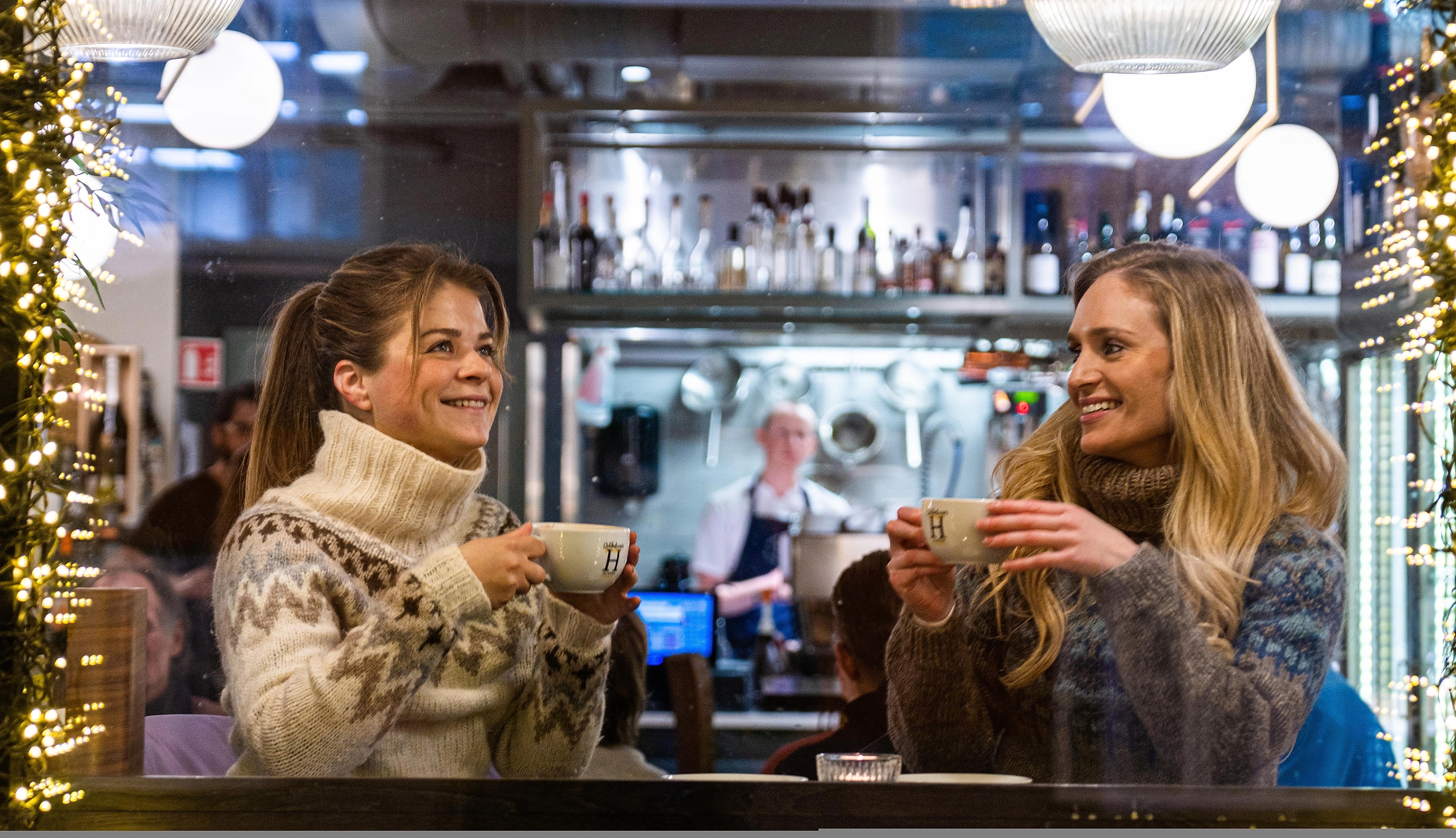 Two girls enjoying hot chocolate at Helmersen delicatessen and wine bar in Tromsø
