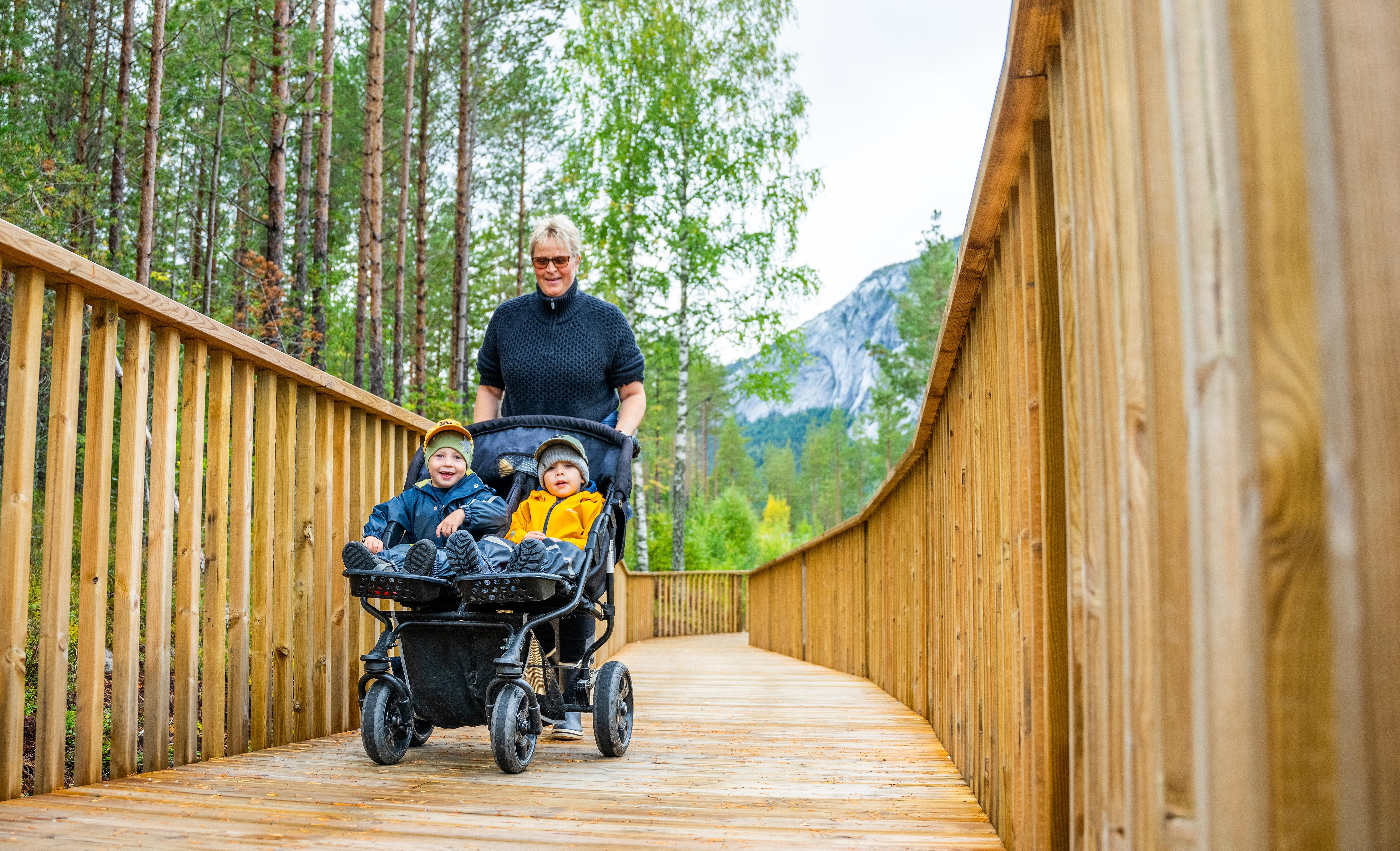 Kvinne med to barn i barnevogn på tur i Tretoppveien i Hamaren aktivitespark i Fyresdal