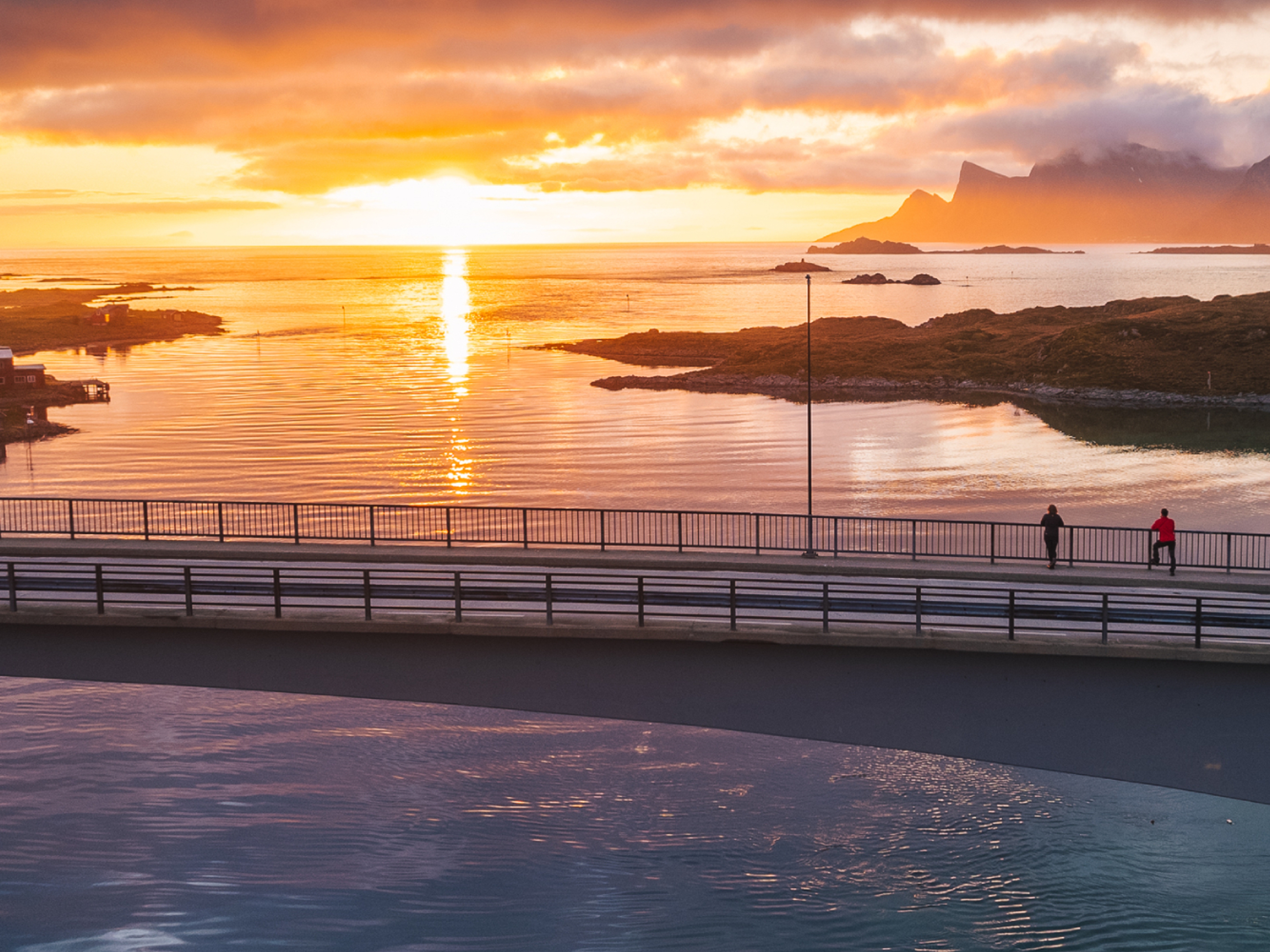 Two people exploring Lofoten under the midnight sun