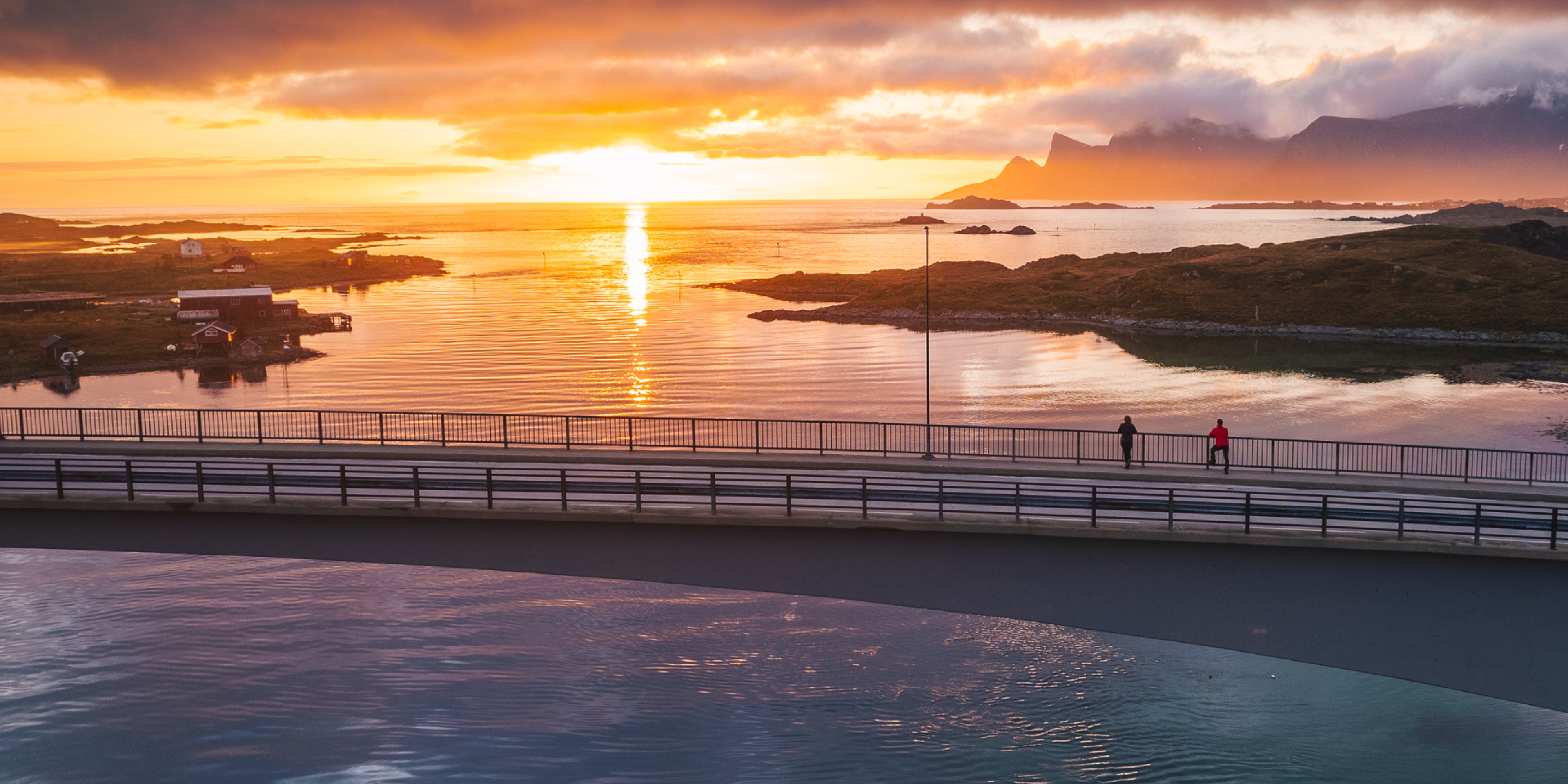 Two people exploring Lofoten under the midnight sun