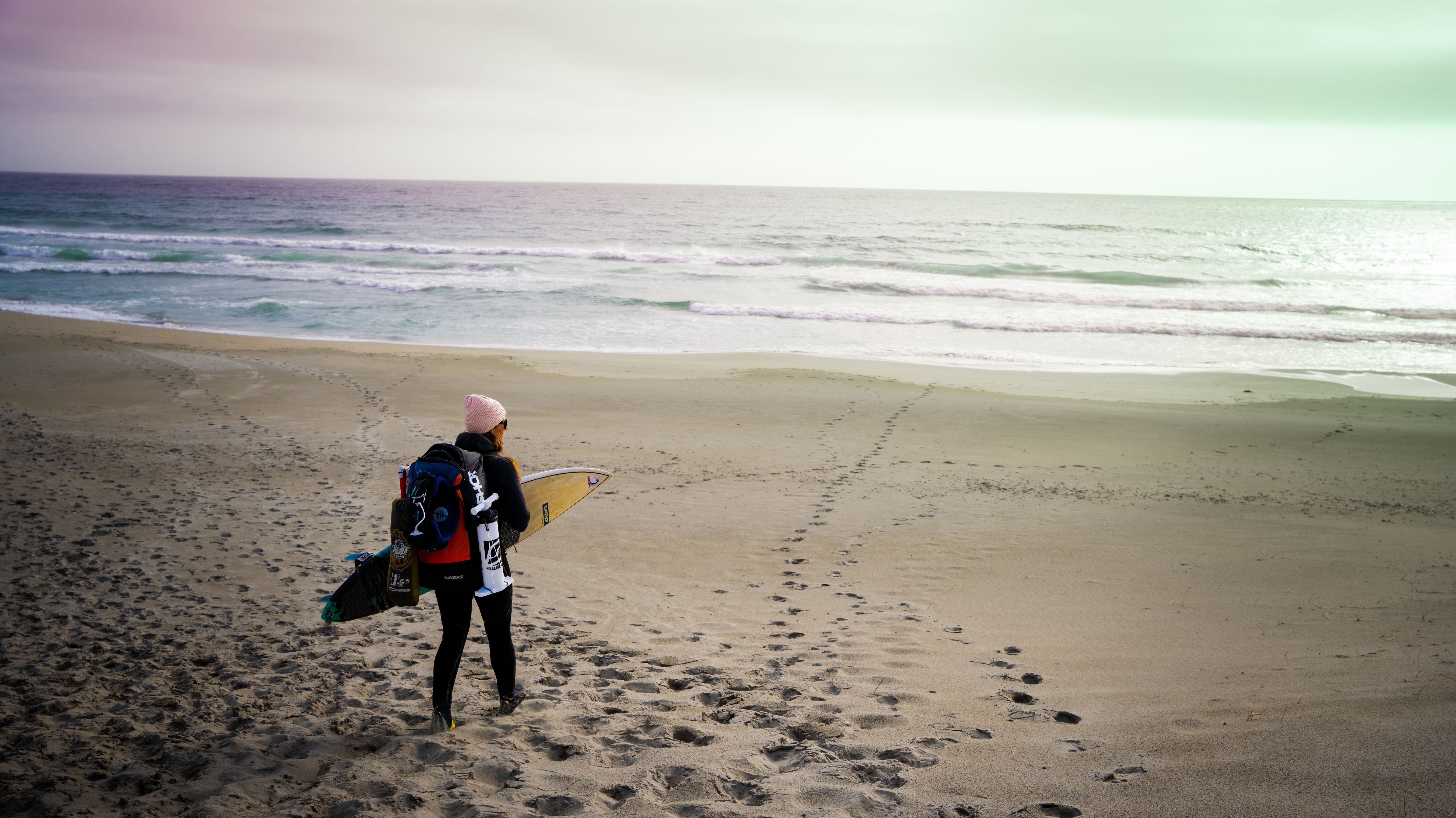 A woman carrying kiting gear at the beach outside of Stavanger, Fjord Norway.