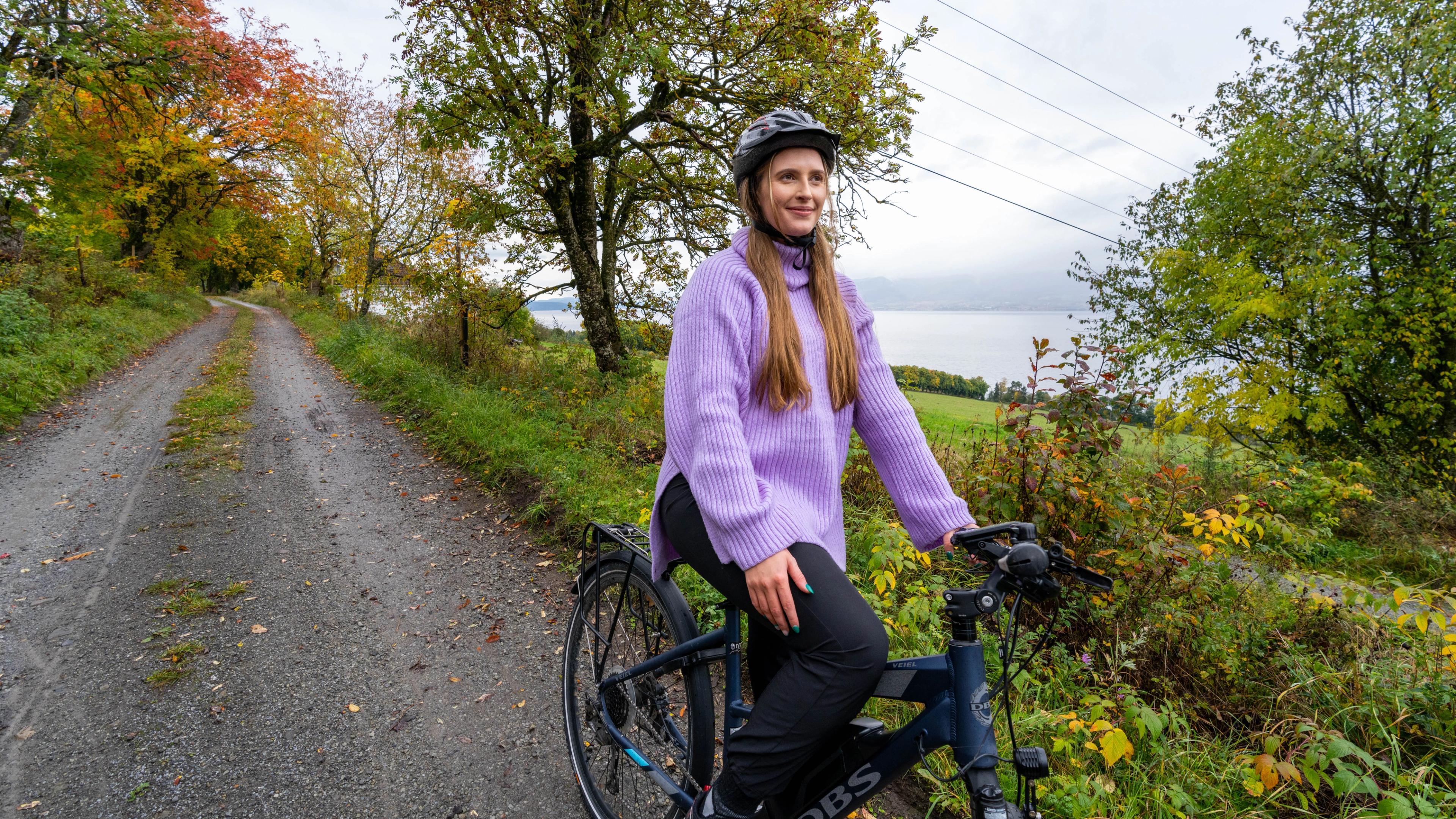 A women cycling at Nes and Helgøya by lake Mjøsa, Eastern Norway.
