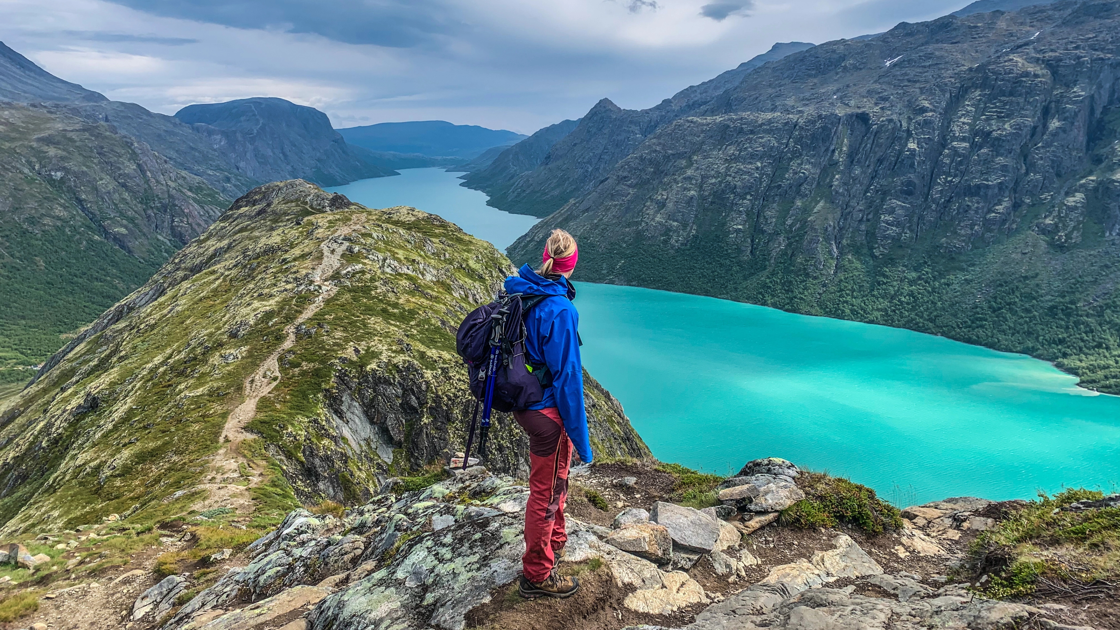 A woman hiking and looking at the Gjendevatnet lake