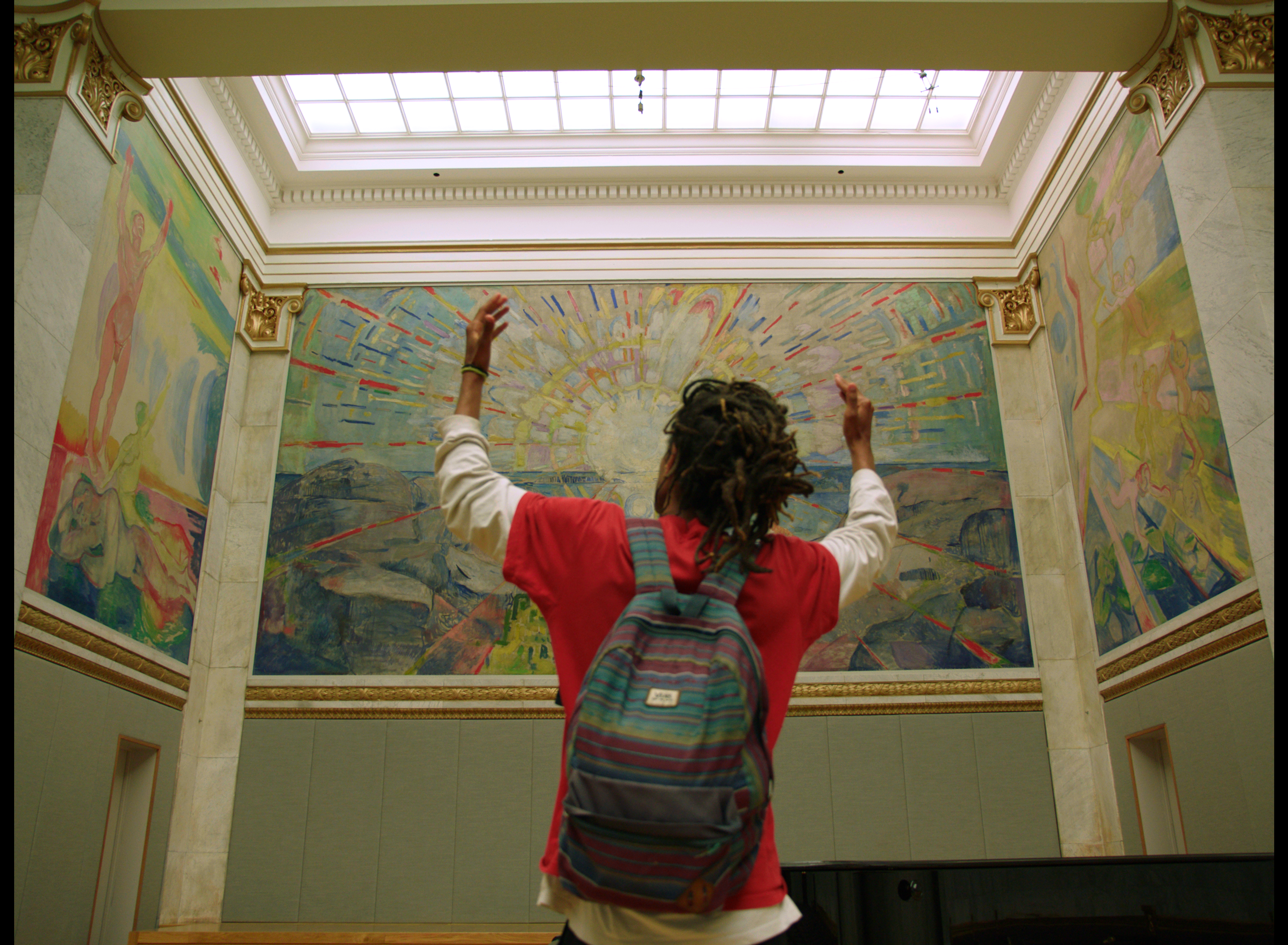 A man is looking at the "The Sun" by Edvard Munch.
