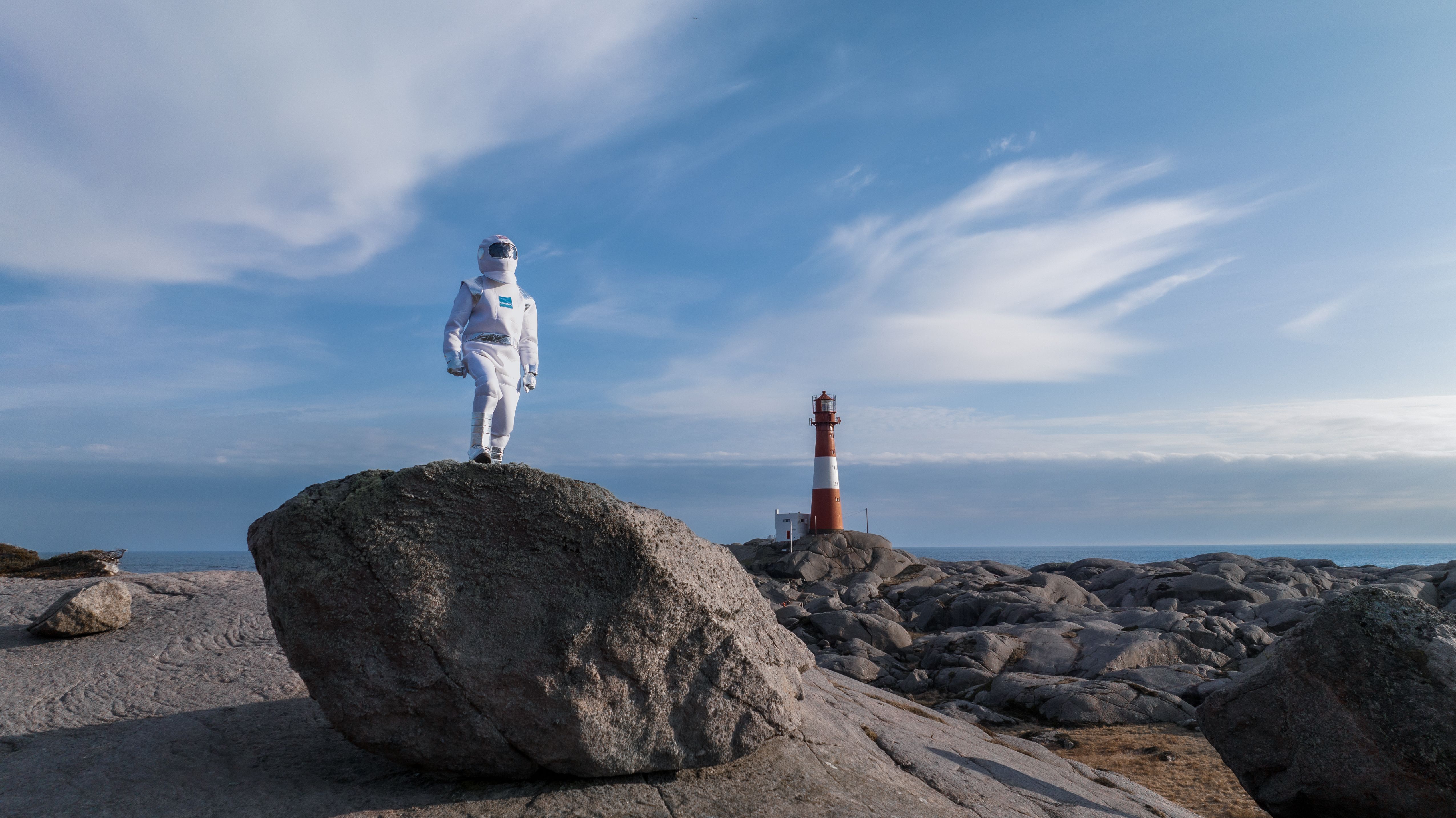 An "astronaut" walking in lunar-like landscape at Eigerøy lighthouse in Egersuns