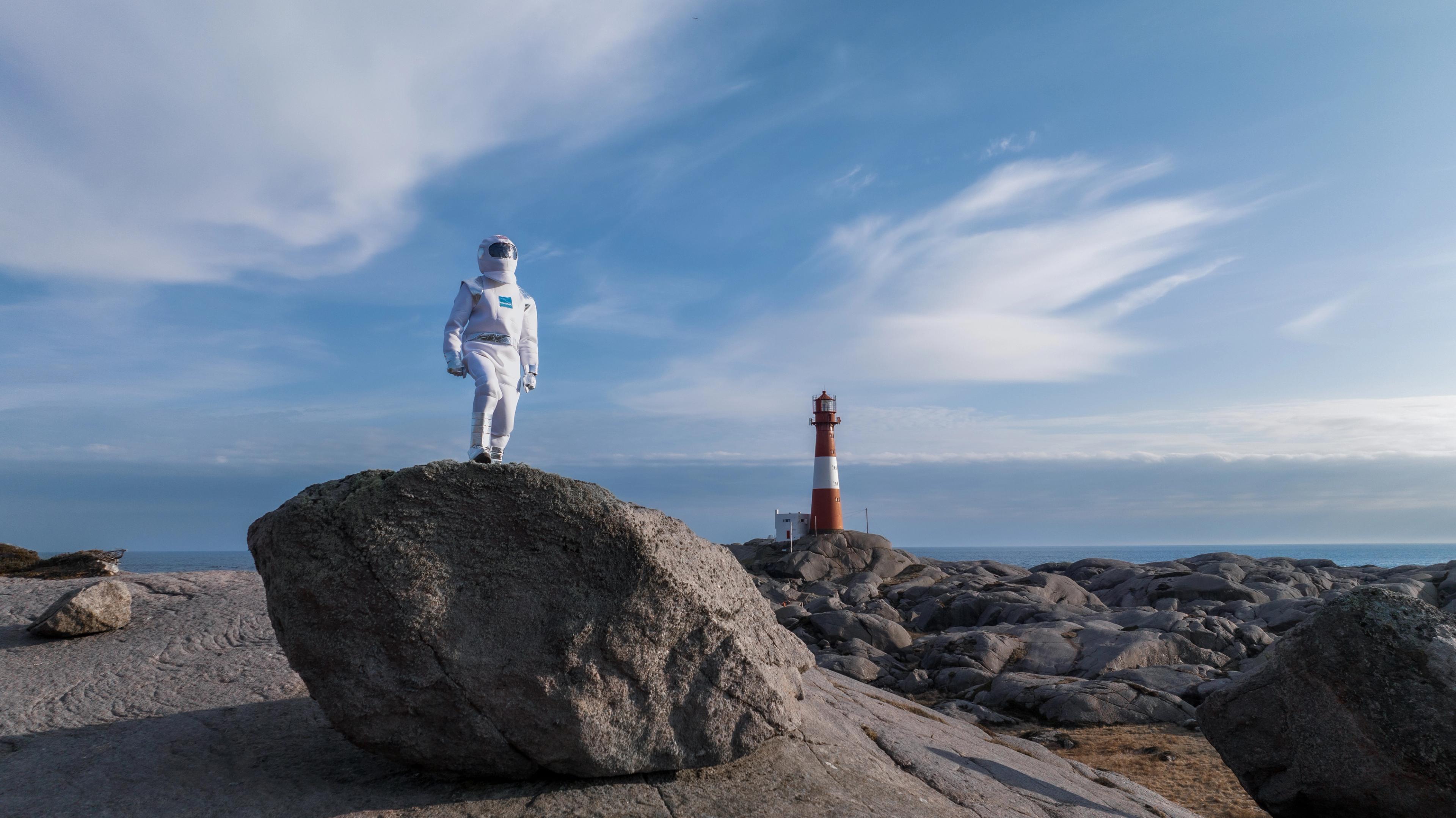 An "astronaut" walking in lunar-like landscape at Eigerøy lighthouse in Egersuns