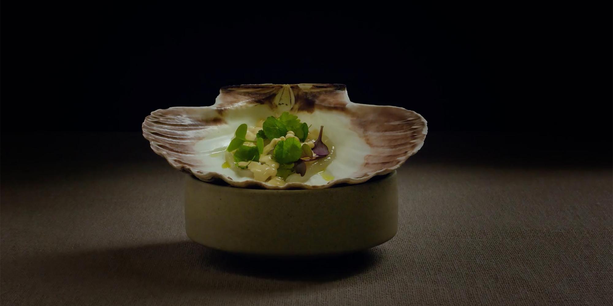 A small dish of food in a seashell at the Norwegian Michelin restaurant Fagn in Trondheim