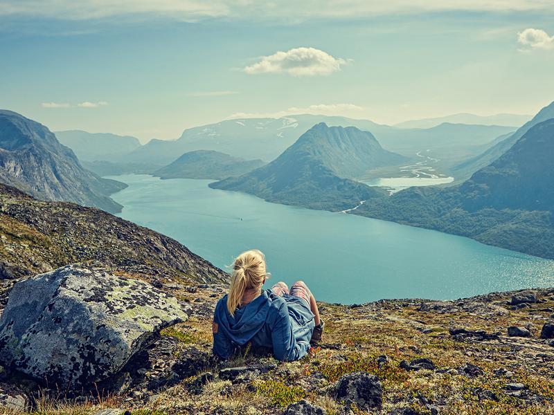A woman enjoying the view of Lake Gjende in the Jotunheimen mountains in Eastern Norway