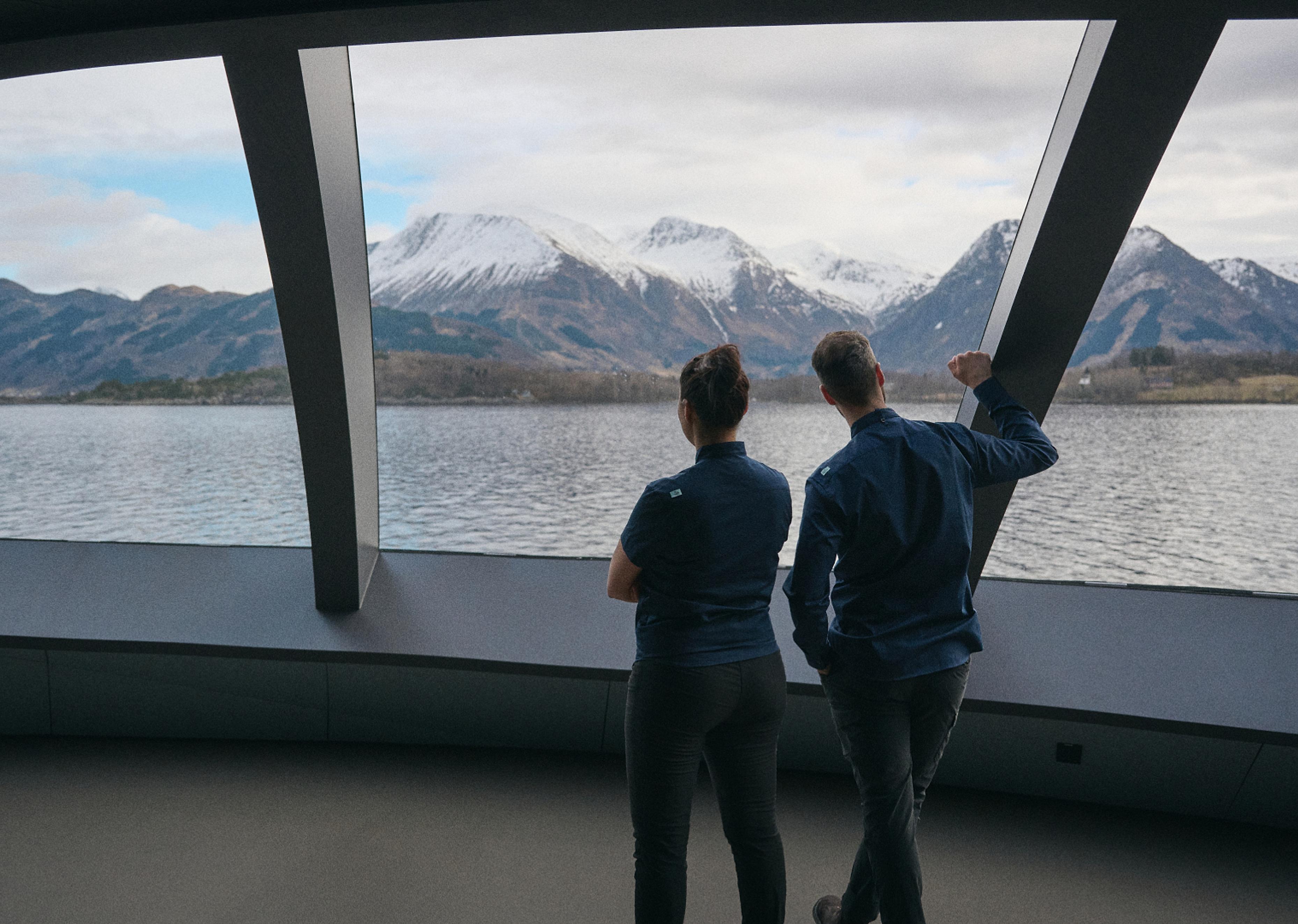 Two people enjoying the view from the Iris restaurant at The Salmon Eye in Hardanger