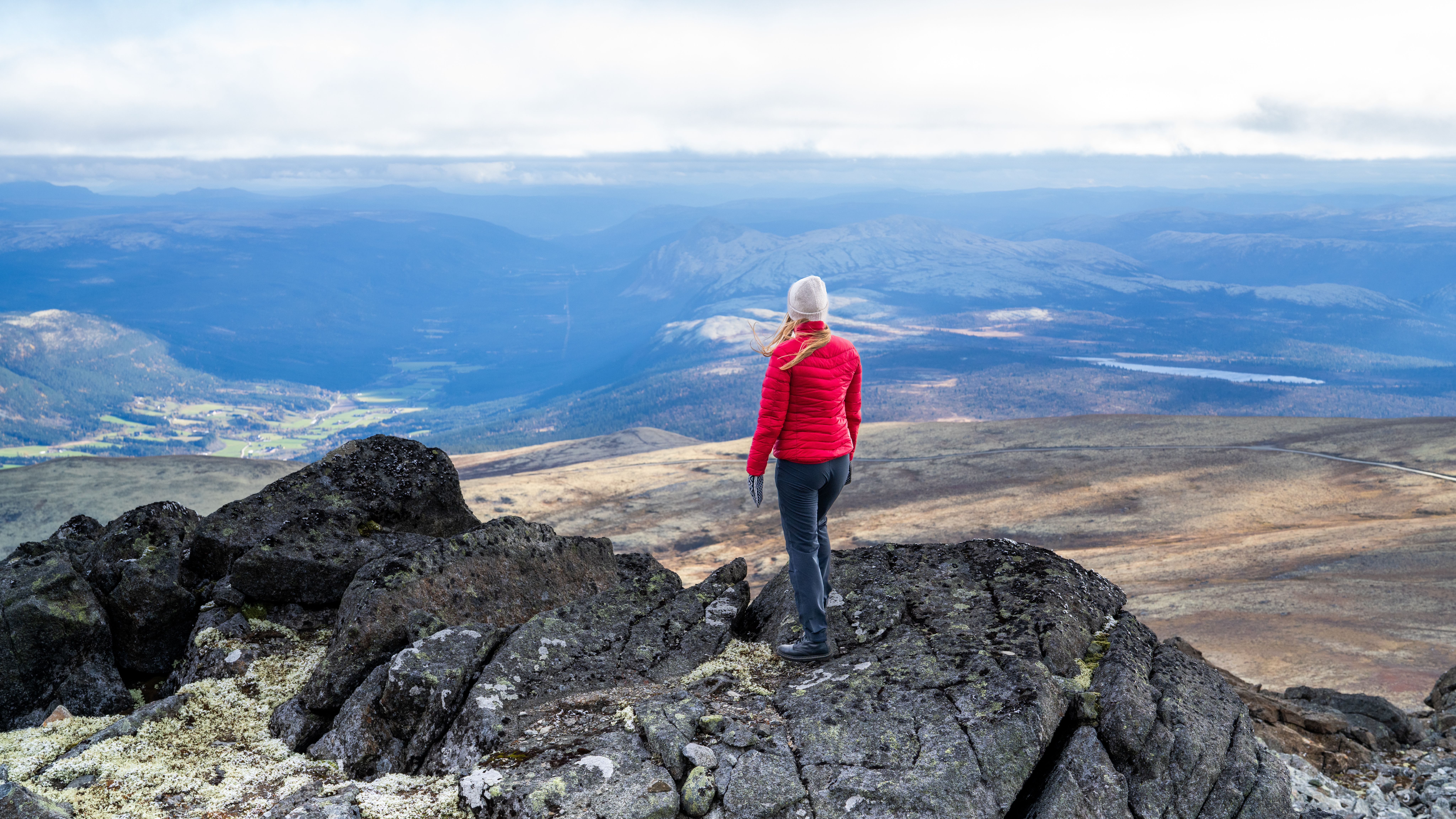 A woman on the top of a mountain looking at the view.