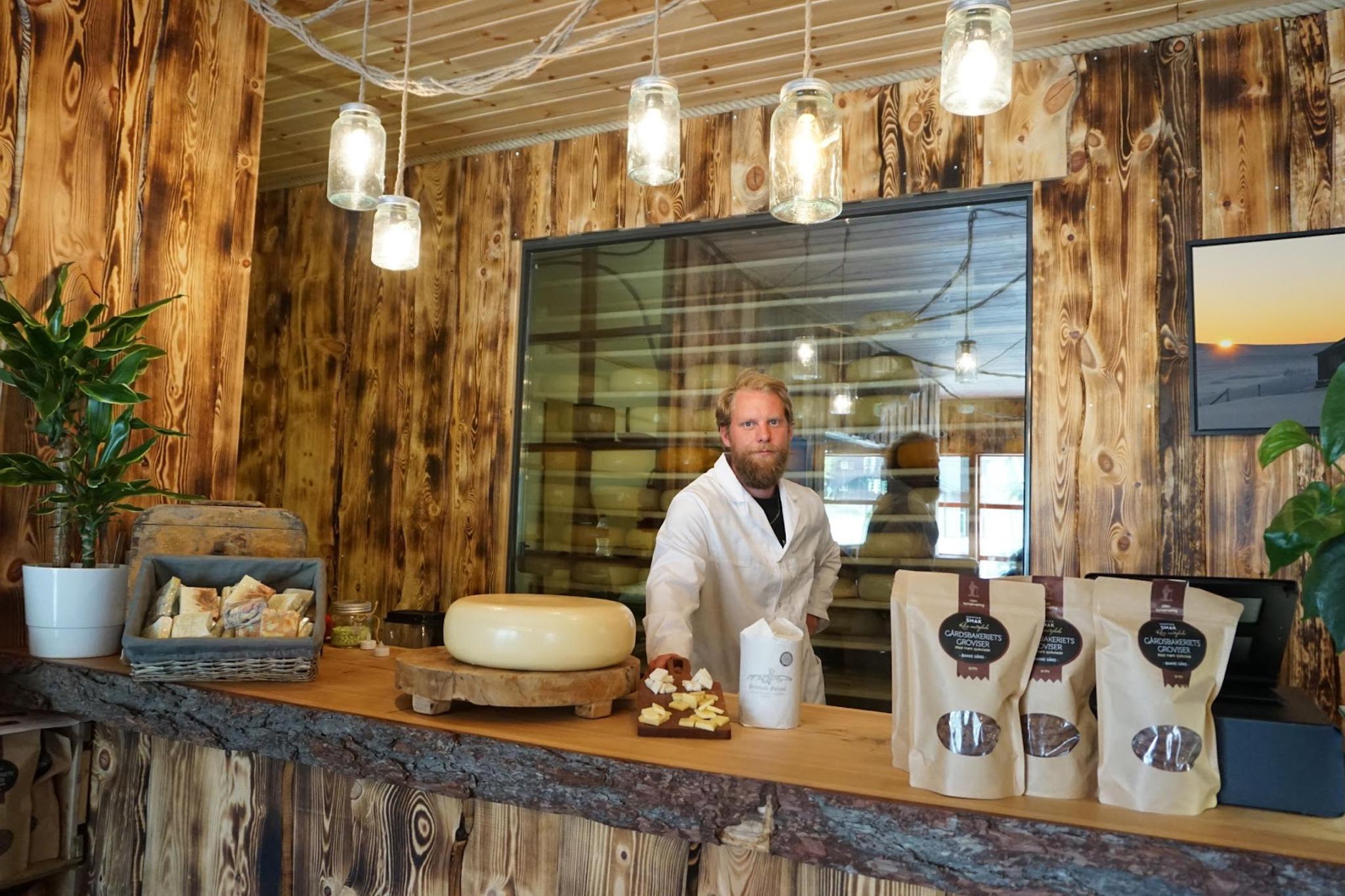 A man standing behind the counter inside the cheese factory Hol Ysteri in Hallingdal, Eastern Norway
