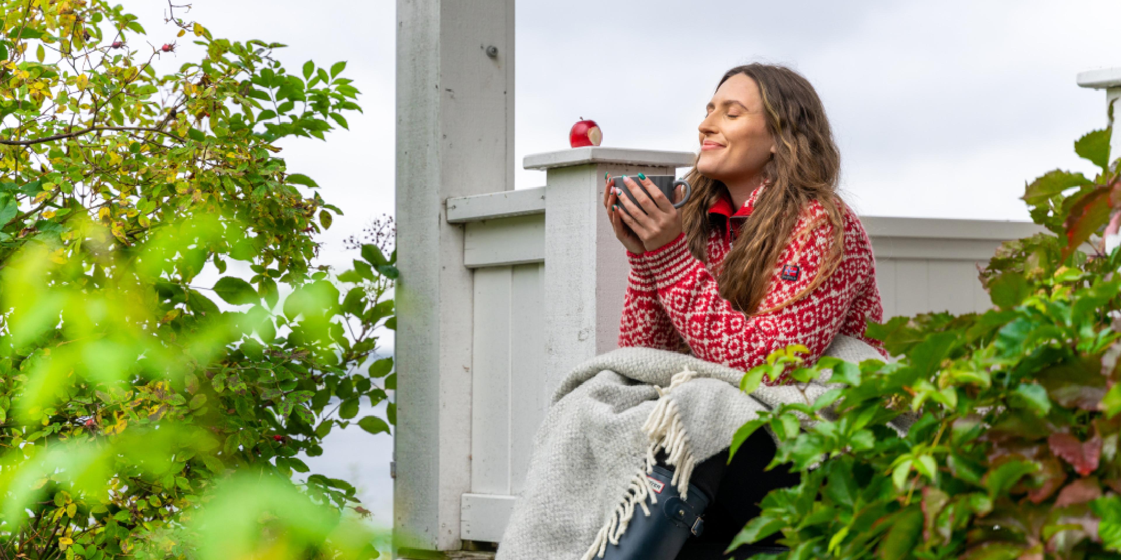 A woman having a good time in the garden at the farm Hoel Gård at Nes, Eastern Norway.