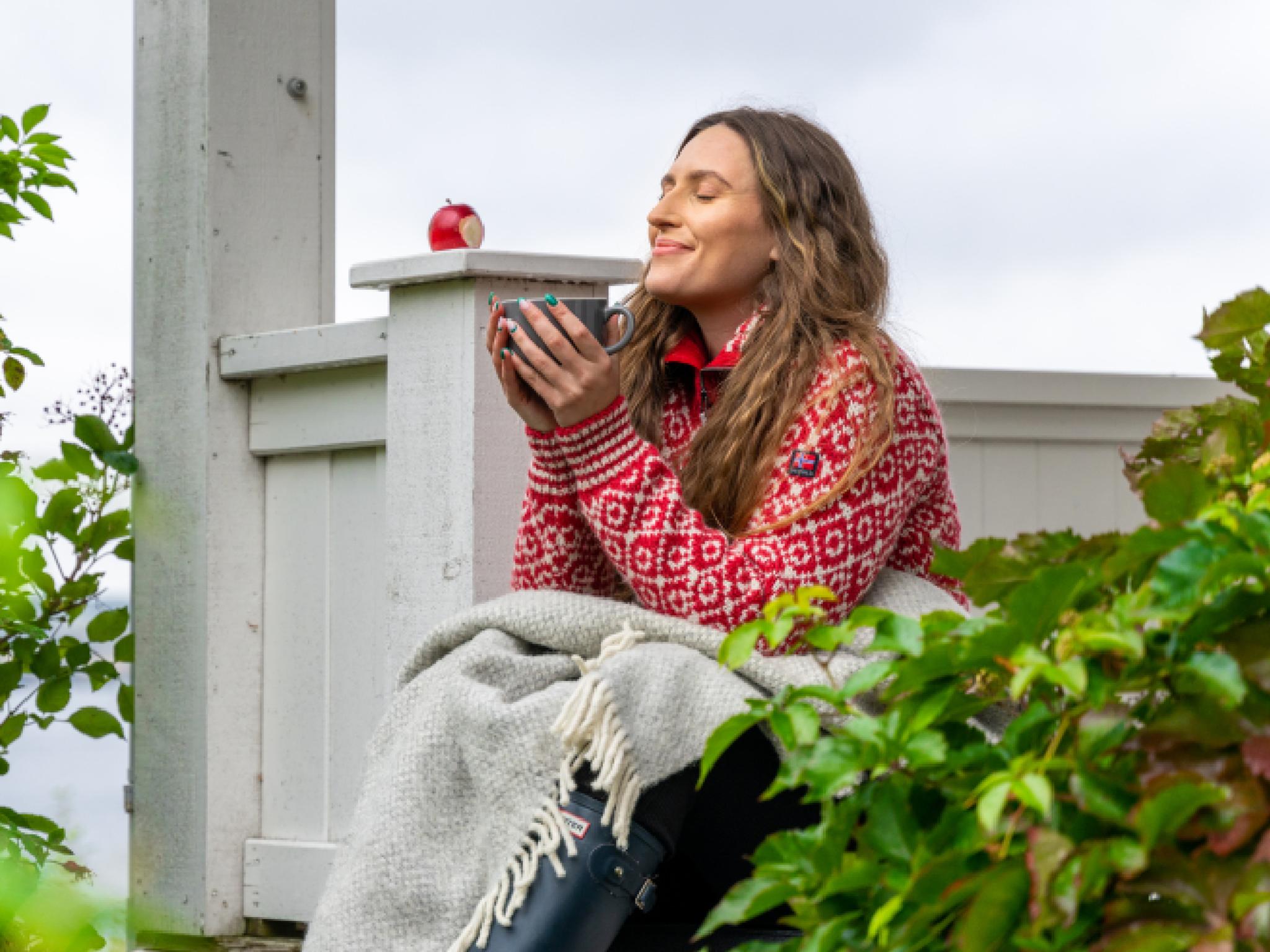 A woman having a good time in the garden at the farm Hoel Gård at Nes, Eastern Norway.