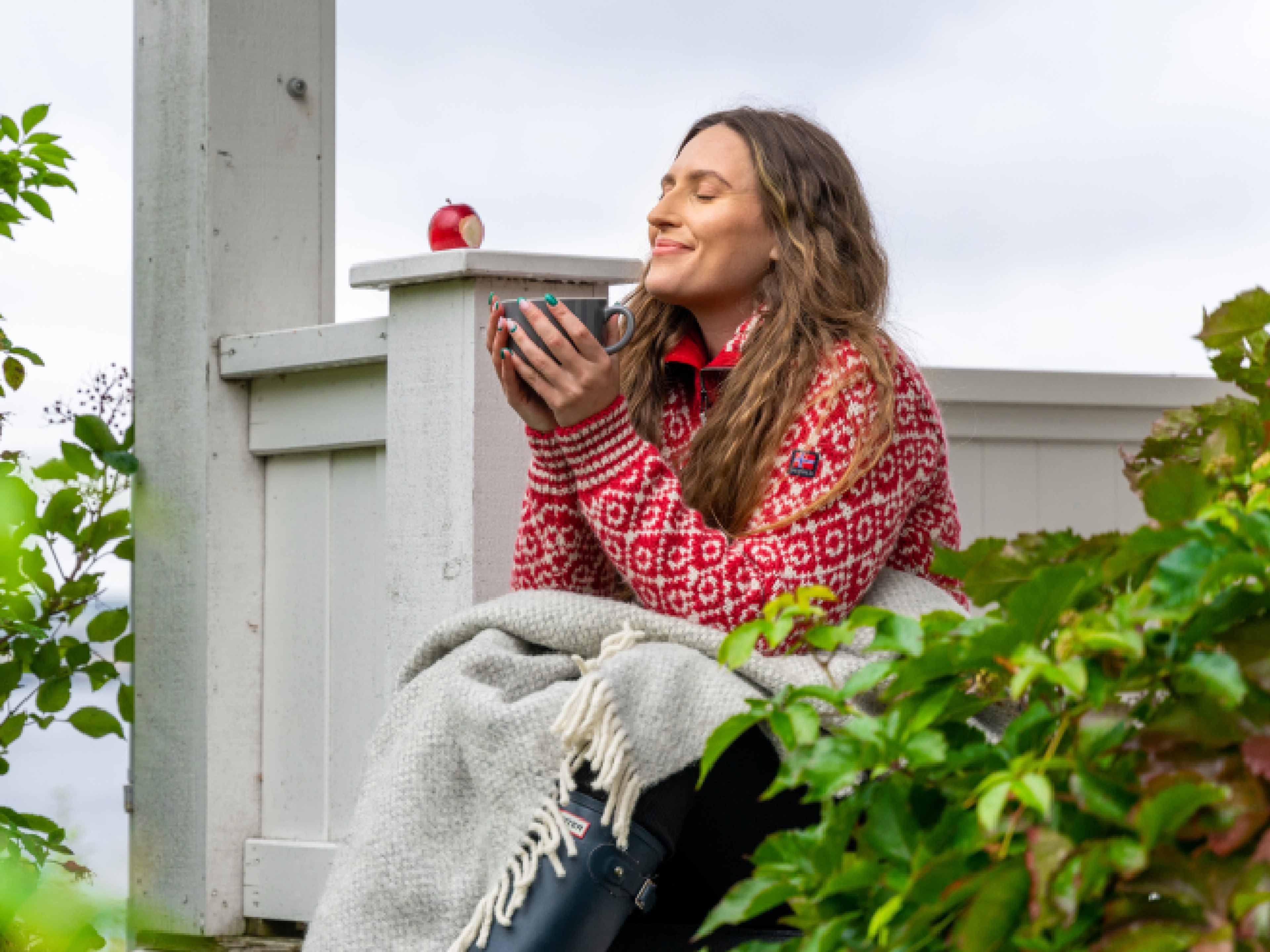 A woman having a good time in the garden at the farm Hoel Gård at Nes, Eastern Norway.