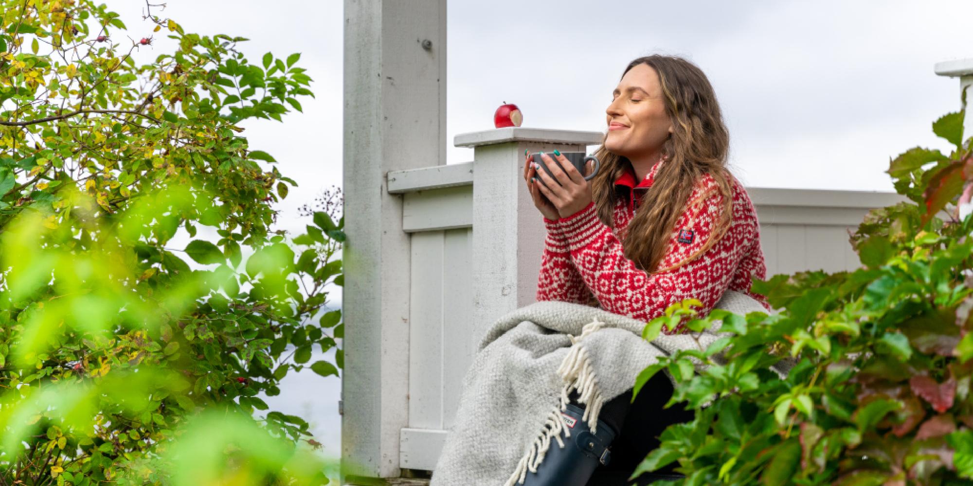 A woman having a good time in the garden at the farm Hoel Gård at Nes, Eastern Norway.