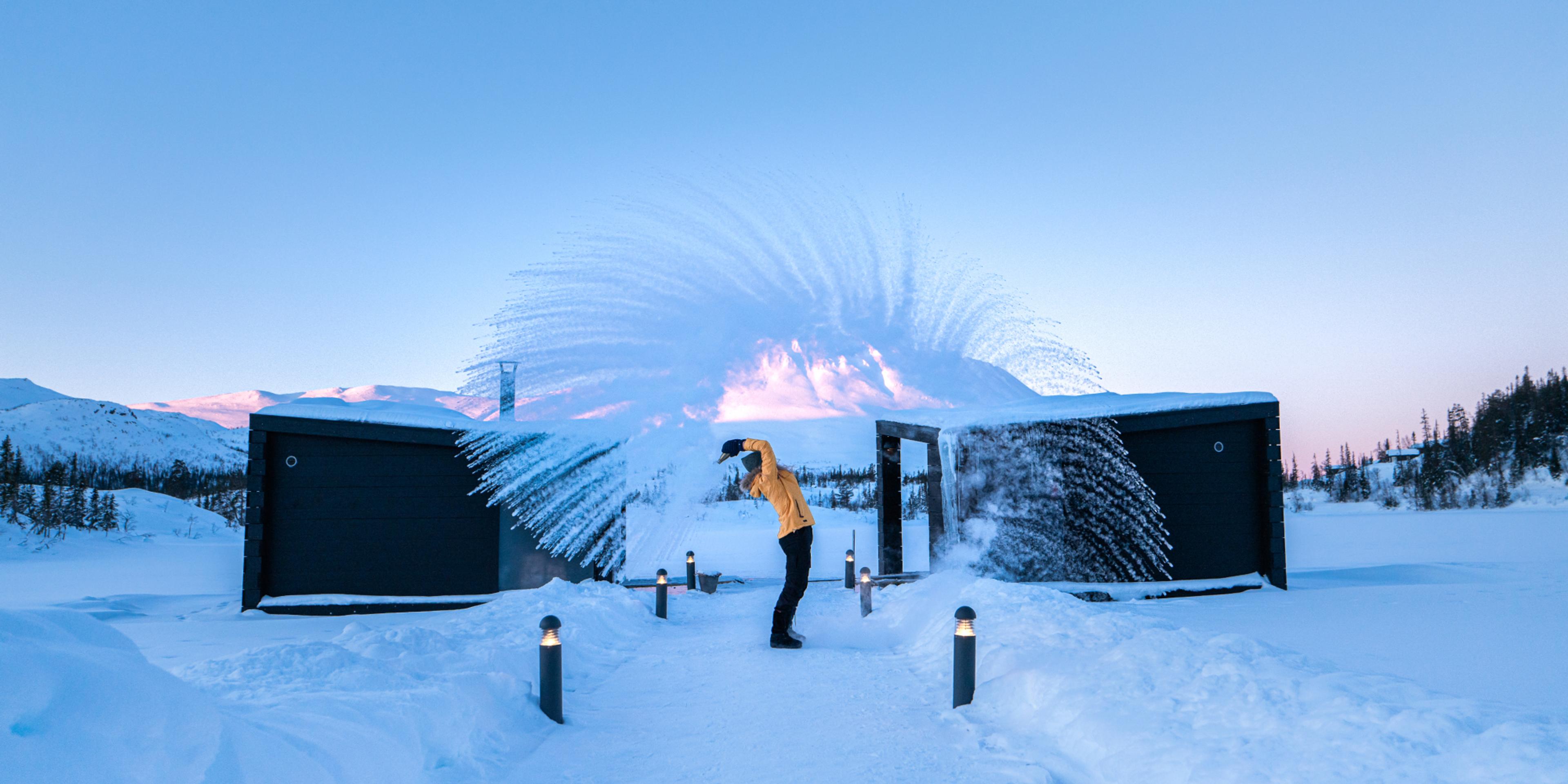 Girl throwing snow in the air by the floating saunas at Gausta, Telemark