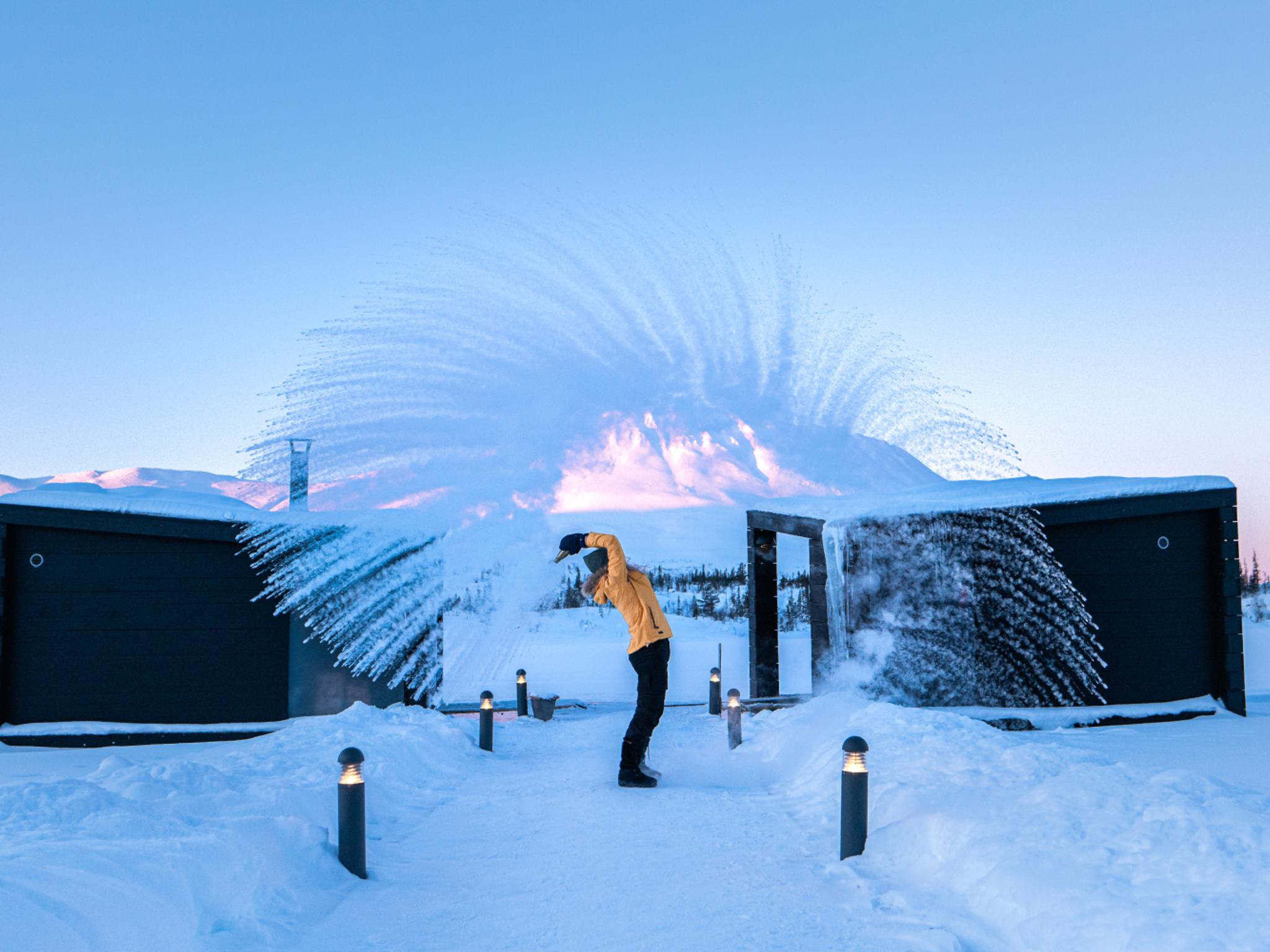 Girl throwing snow in the air by the floating saunas at Gausta, Telemark