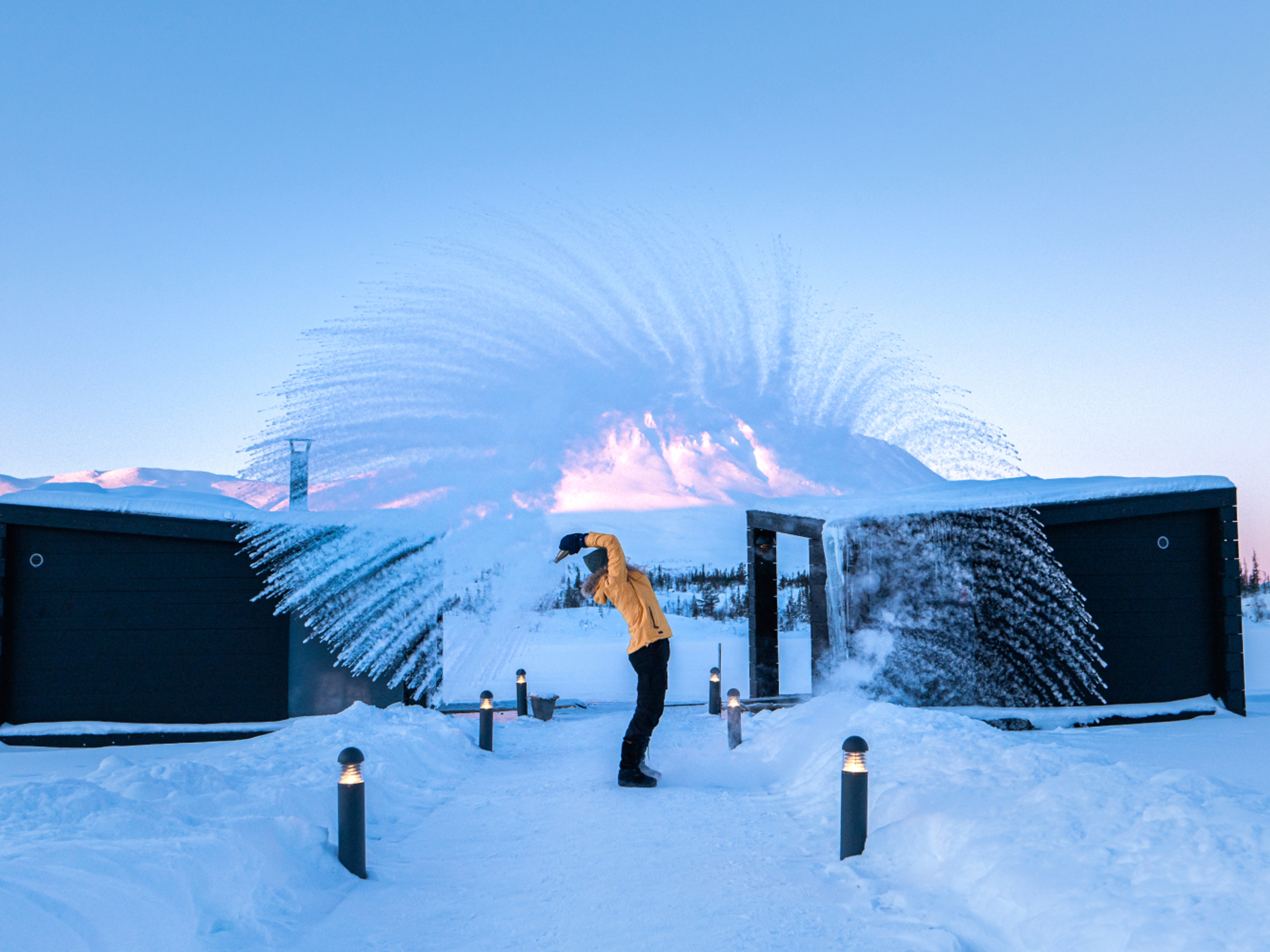 Girl throwing snow in the air by the floating saunas at Gausta, Telemark