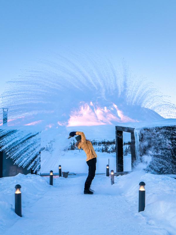 Girl throwing snow in the air by the floating saunas at Gausta, Telemark