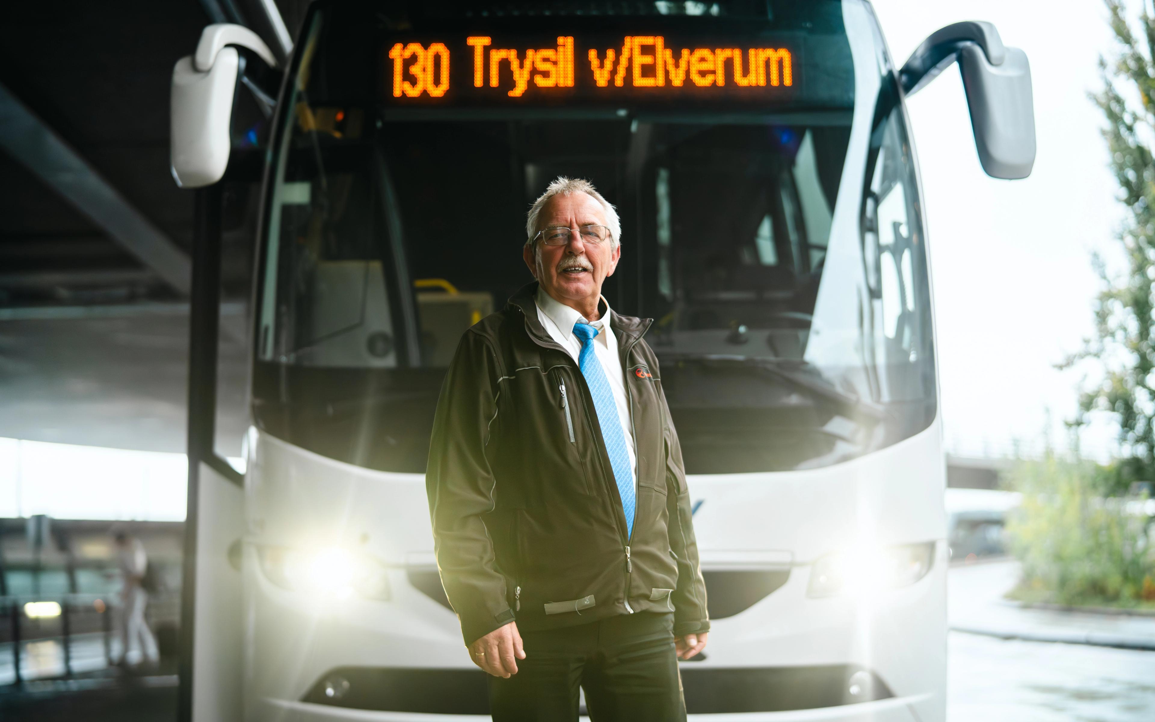 A bus driver in front of his bus.