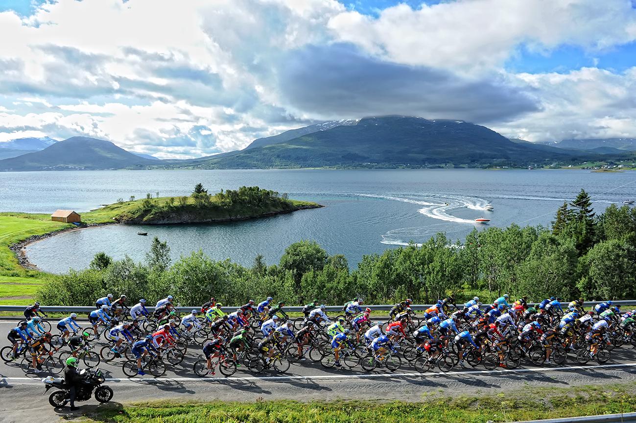 The peloton of the Arctic Race of Norway cycling in the scenic landscape of Northern Norway