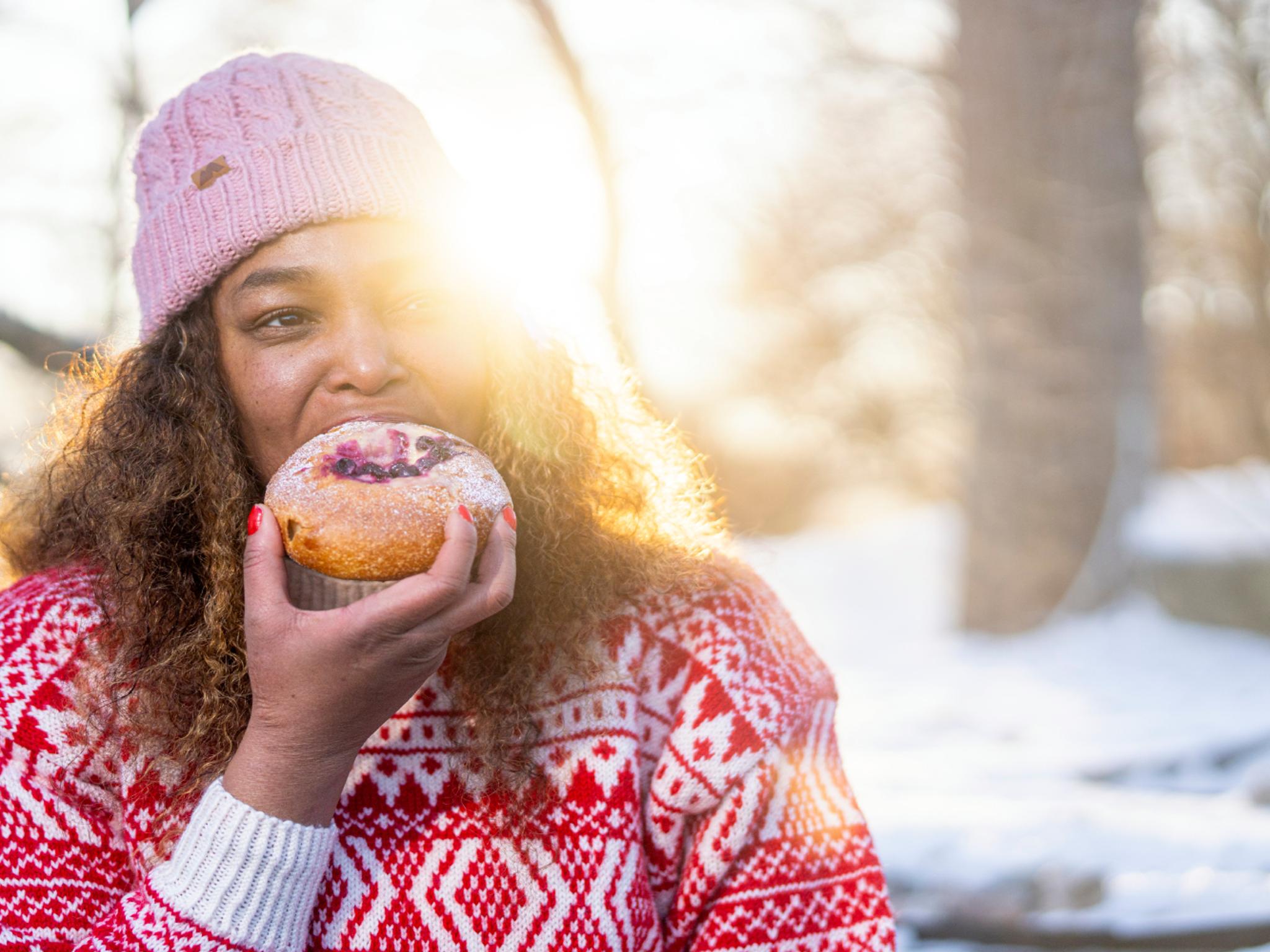 Woman eating bun at the Anne på Landet café, in Frognerparken